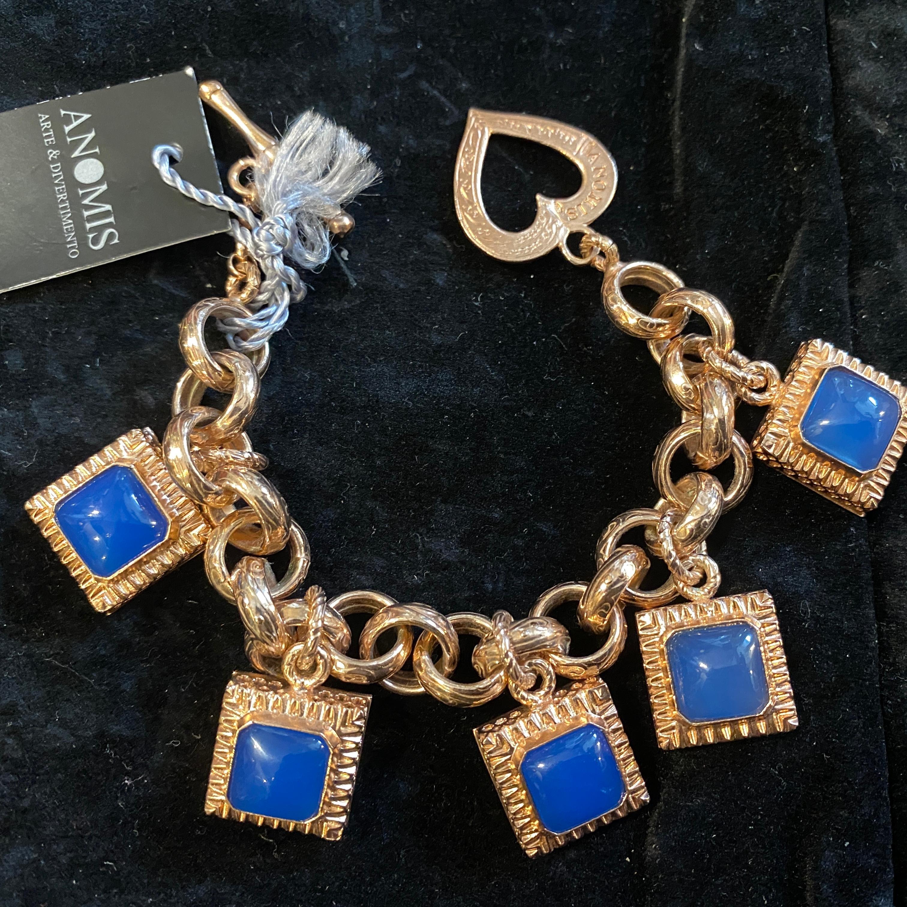 An high quality charm bracelet designed and manufactured in Italy by Anomis in the Nineties, the square cabochon blue agate are in pefect condition as the gilded  sterling silver parts.