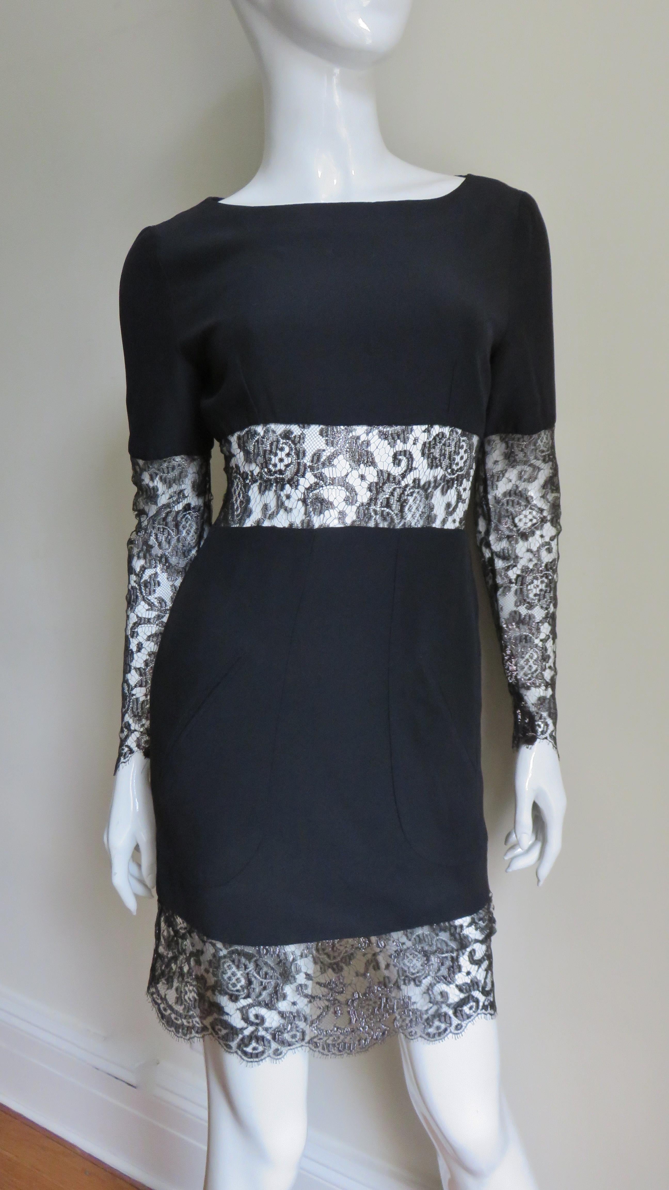 A stunning fine silk wool blend black dress by Karl Lagerfeld.  A lace panel inset surrounds the waist, hem, upper back and sleeves from above the elbow to wrist. It has a bateau neckline and front welt pockets. There is a lace covered button at the