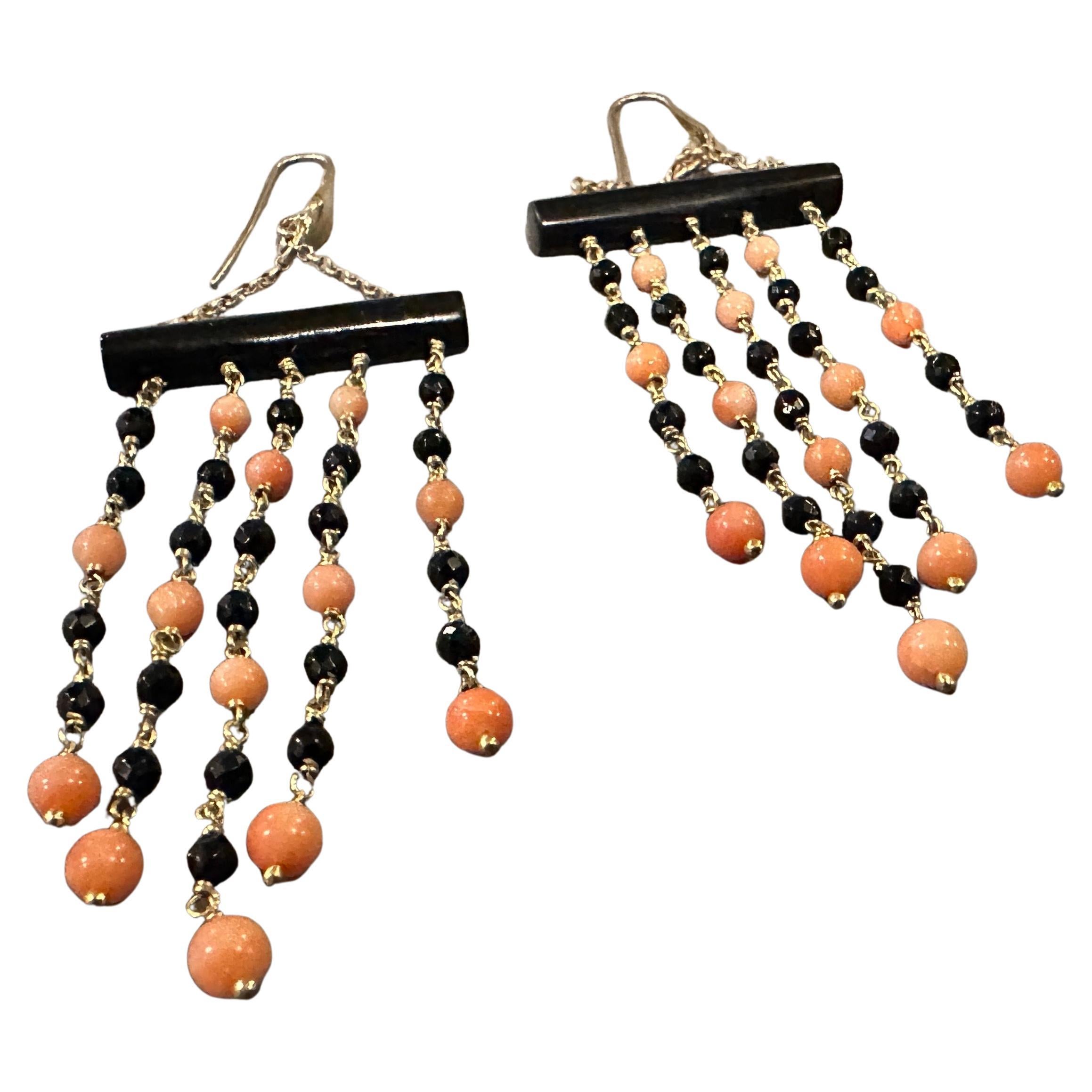 These elegant 1990s chandelier earrings by Carola are a striking blend of luxurious materials and artistic craftsmanship. They feature a bold black onyx bar at the top, from which delicate chains dangle gracefully. The chains are adorned with