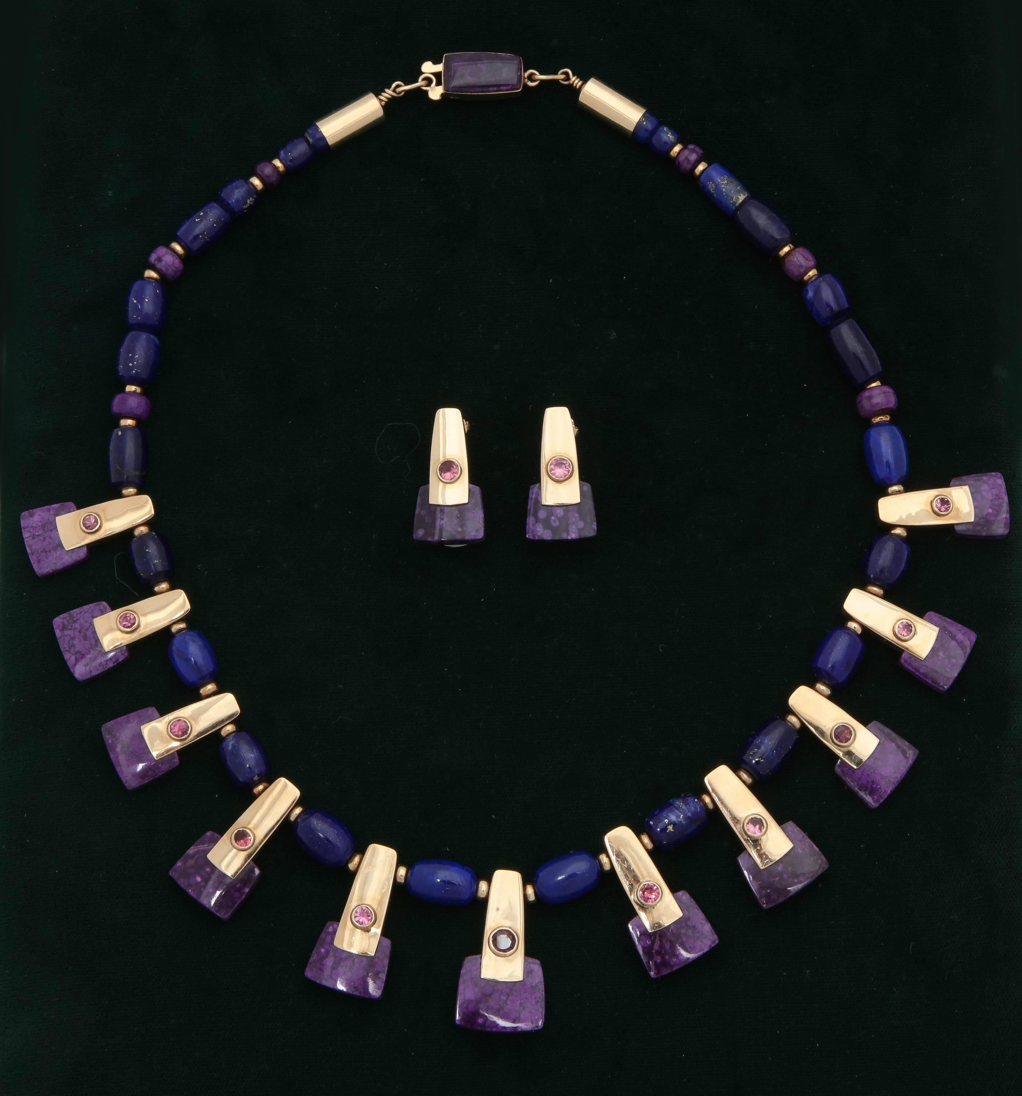 One 14kt Yellow Gold Cleopatra Style Necklace Designed With {12} Rectangular Shaped Custom Cut Purple Sugilite Stones.This Necklace Is Further Embellished with {11} Bezel Set Round Rubelite Stones And Numerous Beautiful Quality Lapis Lazuli Beads.