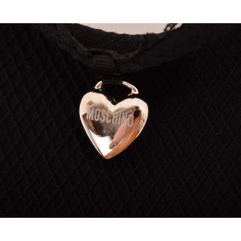 A Timless, 1990's Moschino 'Mare' figure hugging, strappy body con dress, with heart shaped silver coloured metal locket detail.

MADE IN ITALY 

Features:
Figure hugging fit
Swimming costume material
Knicker trimmed sweetheart neckline
Moschino