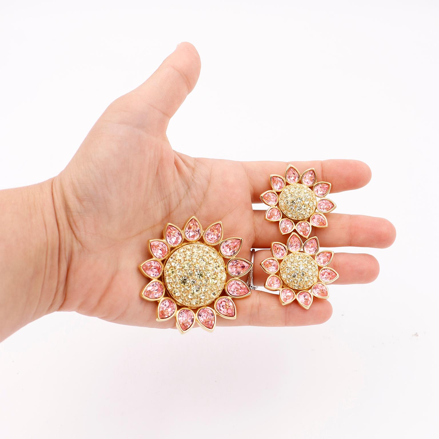 This is a stunning vintage 1990s Swarovski crystal jewelry set that includes a large flower brooch with matching earrings. The lovely vintage brooch is gold plated and completely covered with crystals. The small round yellow crystals form the center