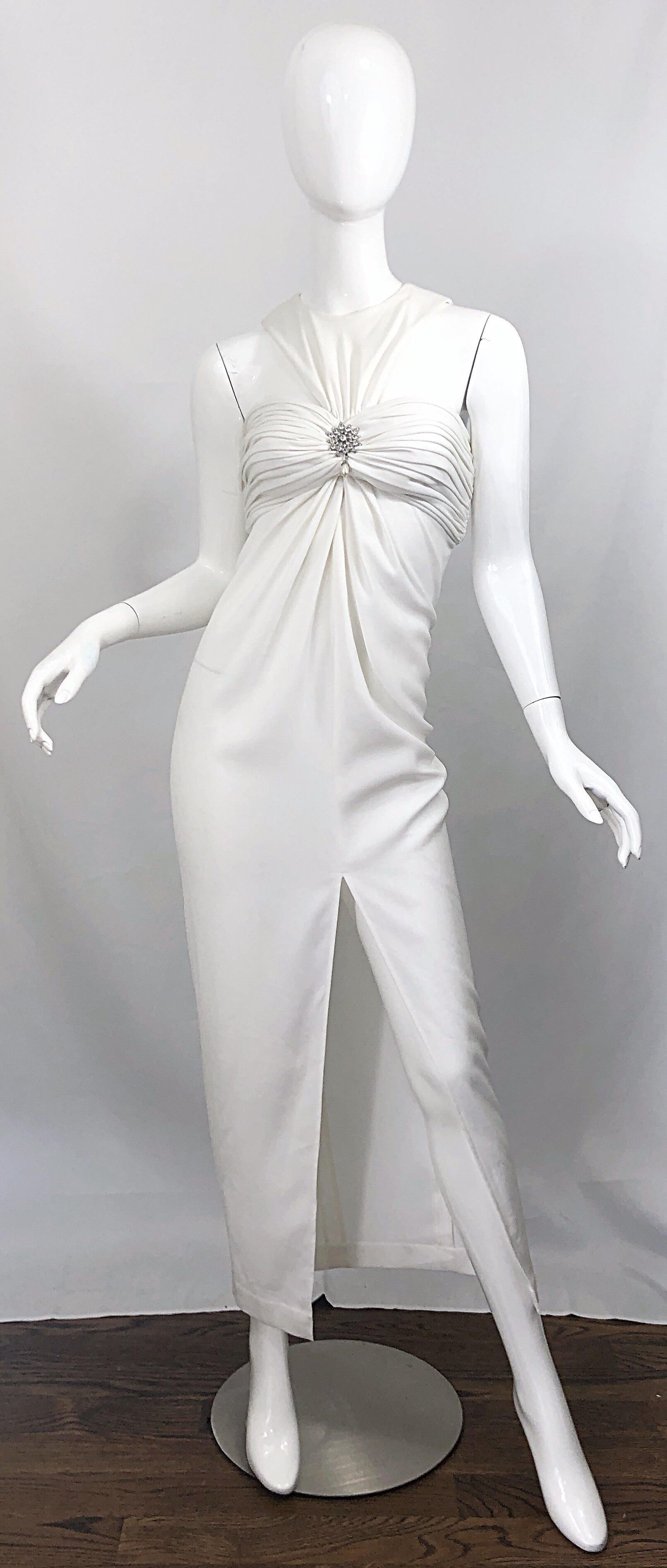Beautiful 1980s vintage TADASHI SHOJI avant garde white 
cut-out full length crepe evening dress! Features cut out detail above bust. Pearl and rhinestone encrusted details at center bust. Hidden zipper up the back with hook-and-eye closure. Slit up