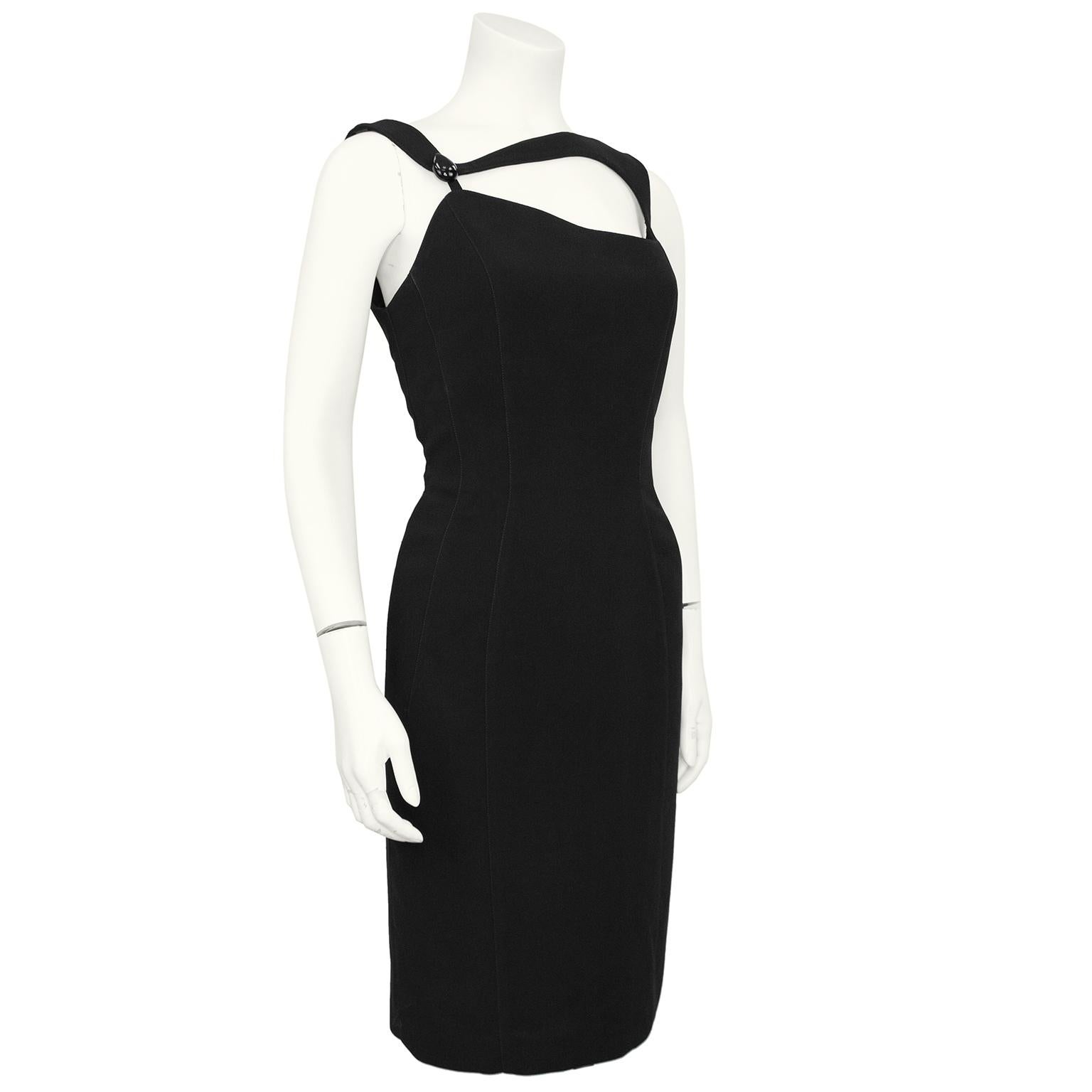 A Mugler take on a little black dress. This dress features a classic bon con shape with interesting and asymmetrical straps and neckline. Domed black egg shaped button on left strap. You can see Mugler's 1960's space age references in this piece.