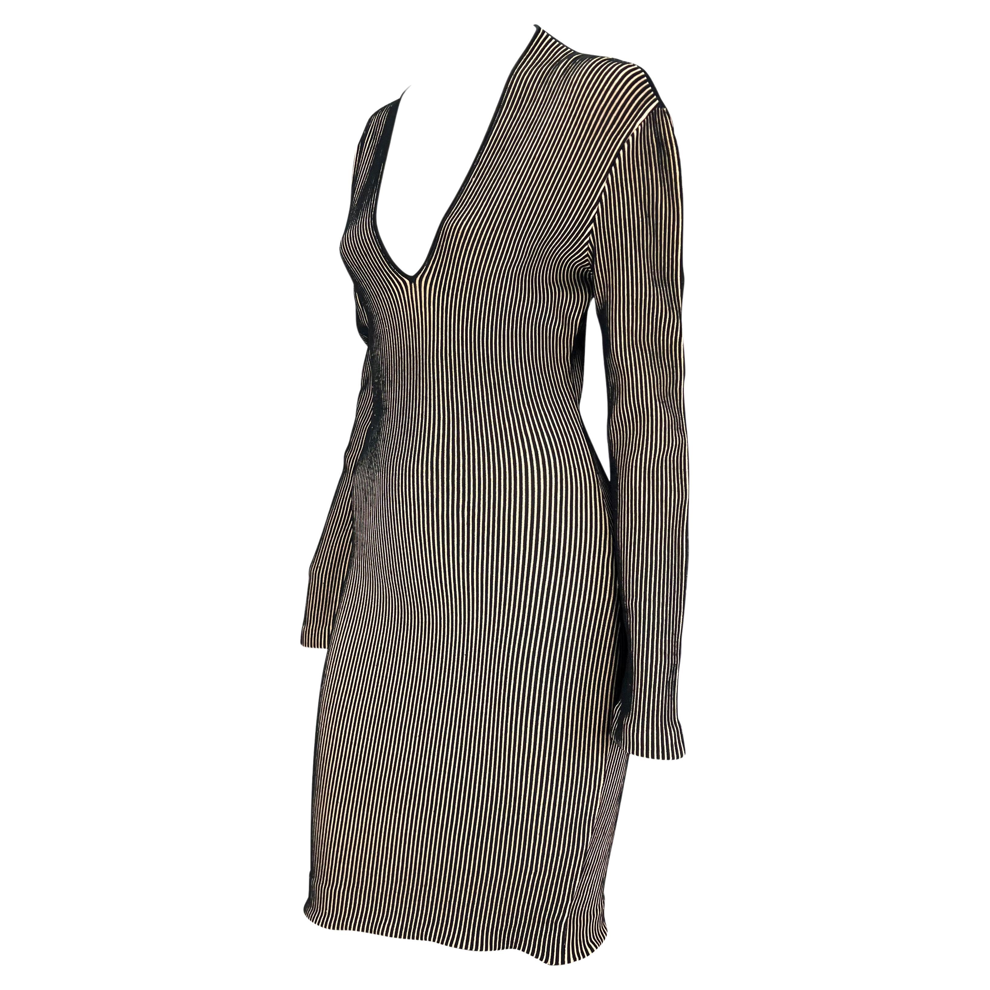 Presenting a beige and black ribbed Thierry Mugler stretch bodycon dress, designed by Manfred Mugler. From the 1990s, this fabulous form-fitting dress features a deep v-neckline, long sleeves, and a midi-length cut. This knock-out dress perfectly