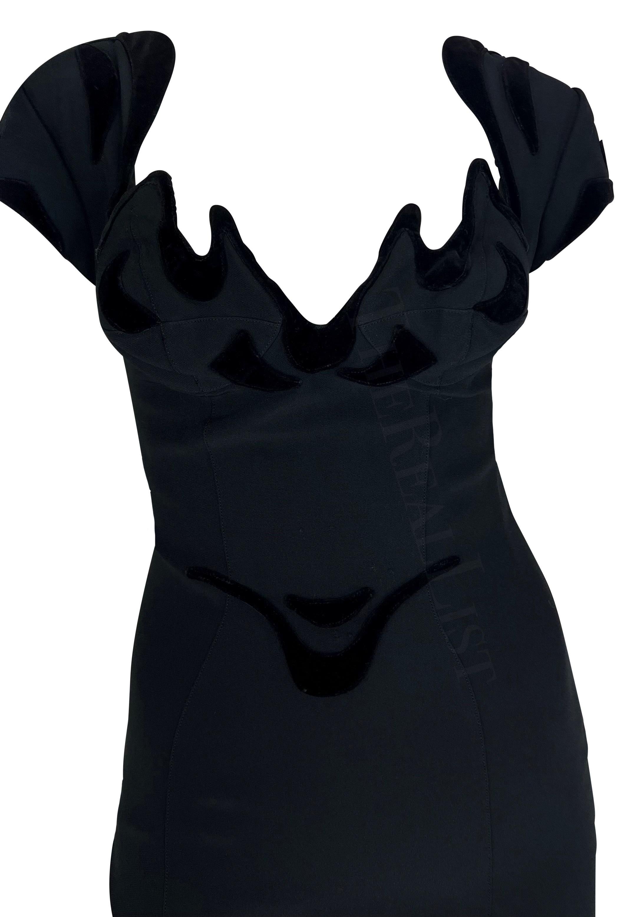 TheRealList presents: a beautiful black Thierry Mugler dress, designed by Manfred Mugler. From the 1990s, this ultra sexy dress features an abstract neckline and petal sleeves. The dress is made complete with black velvet accents that outline the