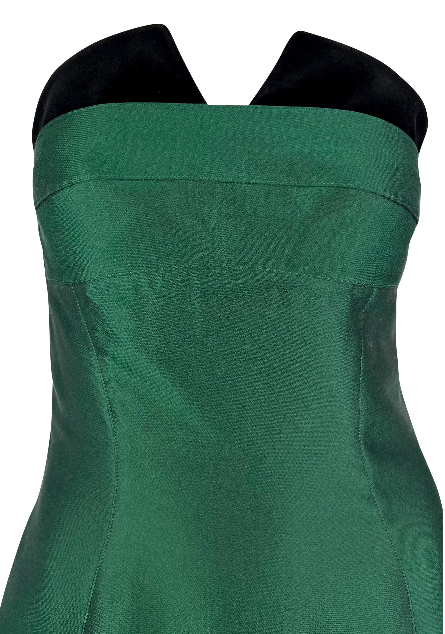 This stunning emerald green Thierry Mugler mini dress features black velvet accents at the bust and hem. This strapless dress from the mid-1990s is made complete with a tiered hem, a pointed bust, and the perfect satin sheen.

Approximate