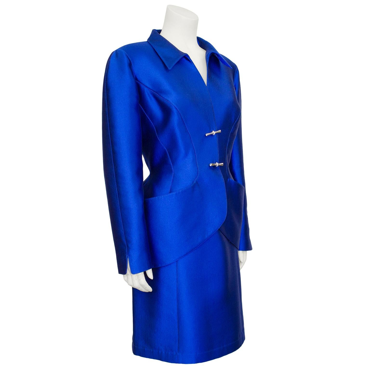 Thierry Mugler was known for his avant-garde and architectural, yet hyper-feminine designs, and this 1990s skirt suit is no exception. Crafted from a metallic royal blue wool silk blend, this suit is fabulous worn together, but the individual pieces
