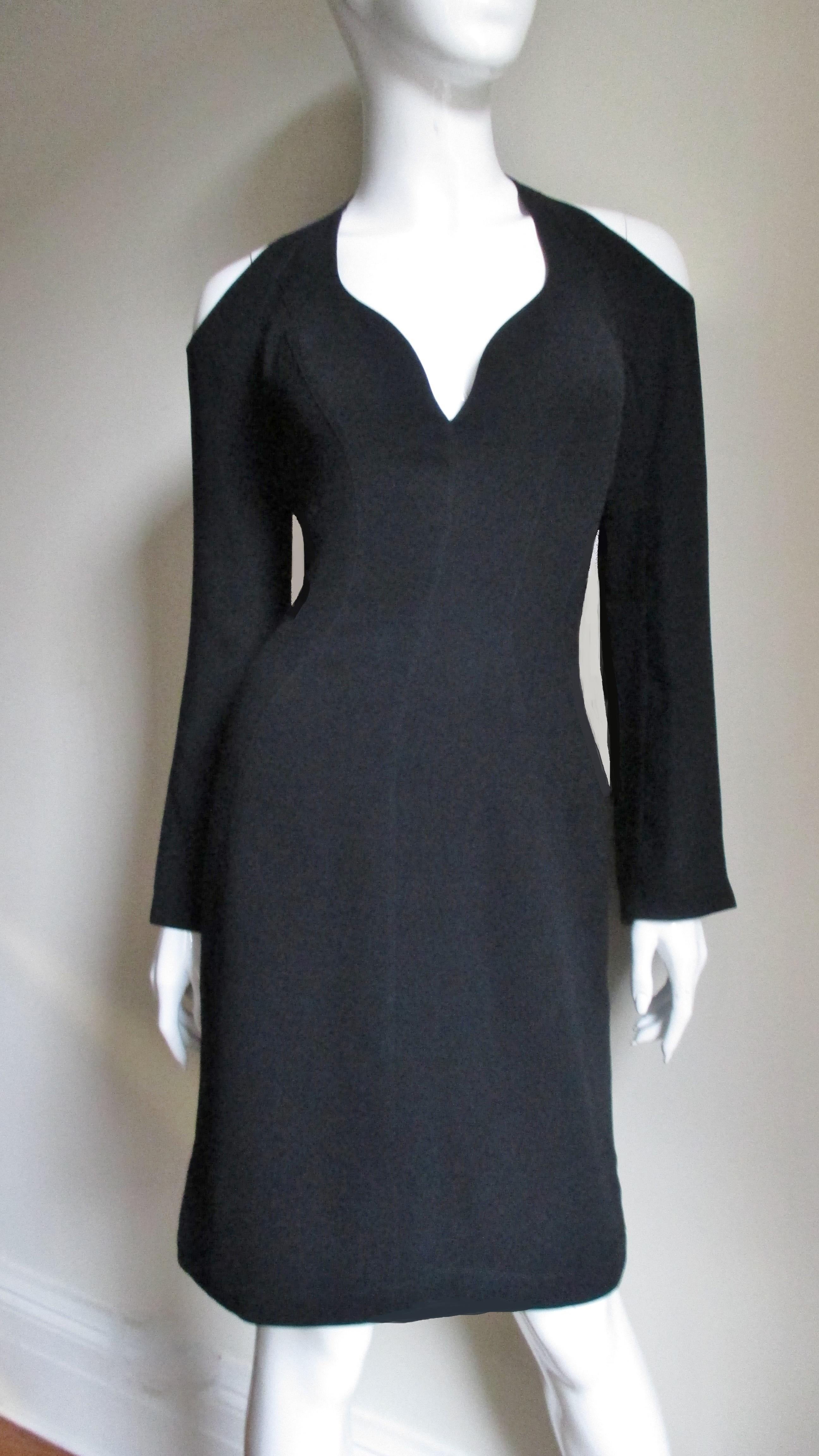 A sexy shoulder and cleavage baring dress in a rich black synthetic blend from Thierry Mugler.   It has a sweetheart plunge neckline, long sleeves that gently flare to the cuff and exposed shoulders front and back. A simple fitted dress with lots of