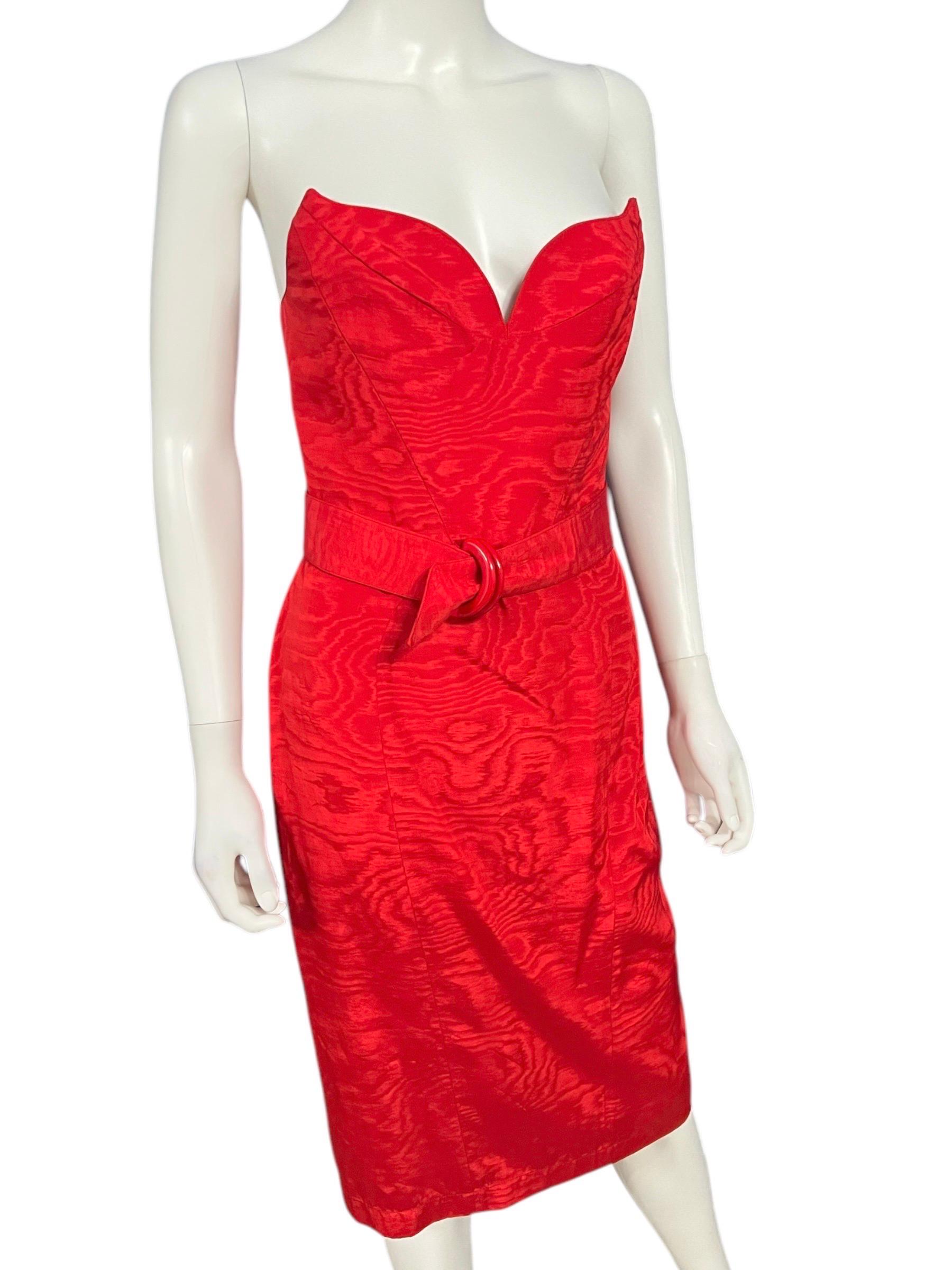 Stunning vintage Thierry Mugler knee-length strapless dress in a vibrant red color. This dress features a structured, winged corset style bodice with a plunging sweetheart neckline which adds a dramatic element to the dress. The fabric has a subtle
