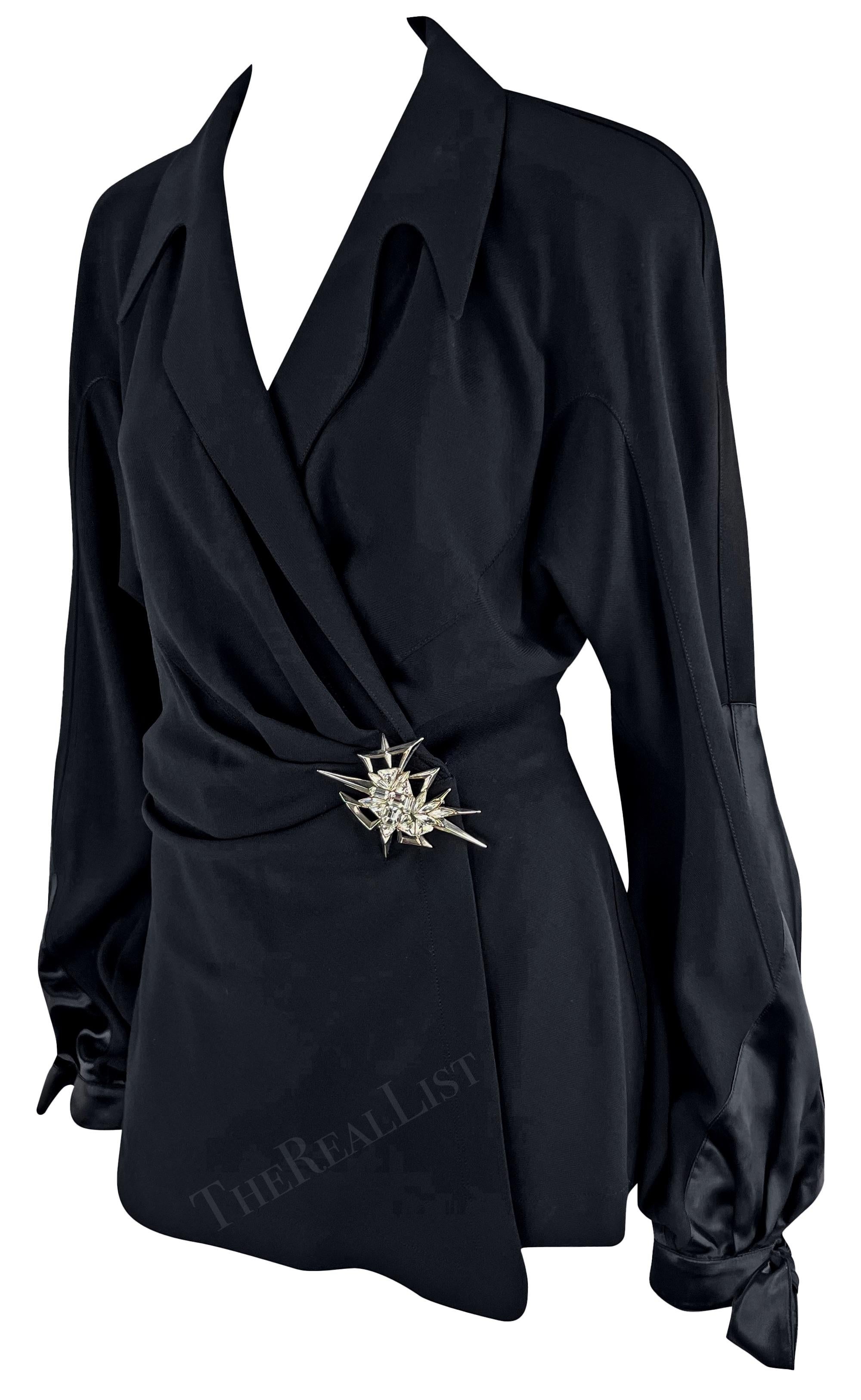 Voici une superbe pièce des années 1990, un fabuleux blazer noir à manches ballon conçu par Manfred Mugler pour Thierry Mugler. Ce blazer chic est doté d'une grande broche argentée recouverte de strass. Il se distingue par ses manches ballon