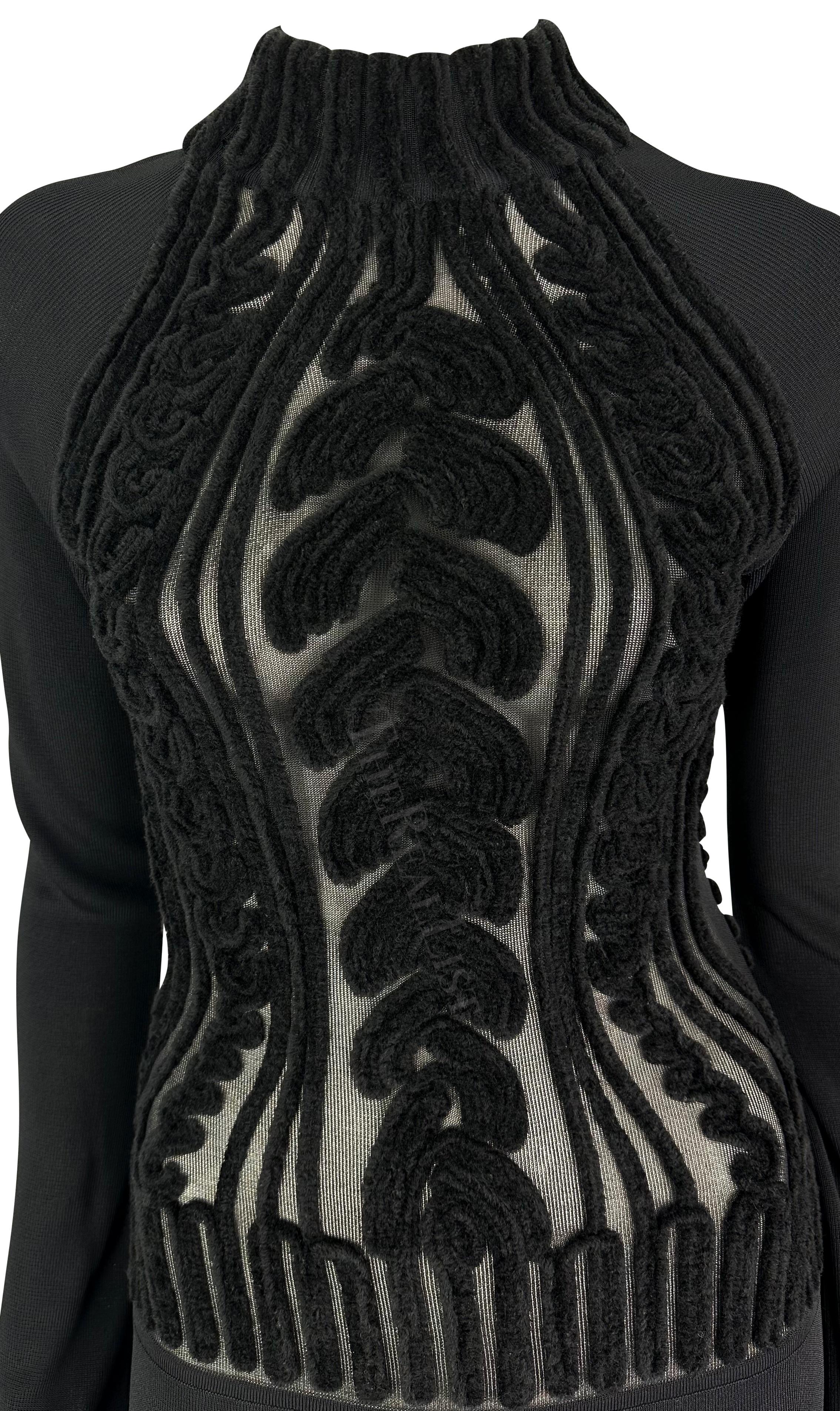 Présentation d'une superbe robe à manches longues en maille noire Thierry Mugler, conçue par Manfred Mugler. Datant du milieu des années 1990, cette robe bodycon en tricot présente une encolure fantaisie et se distingue par un torse transparent avec