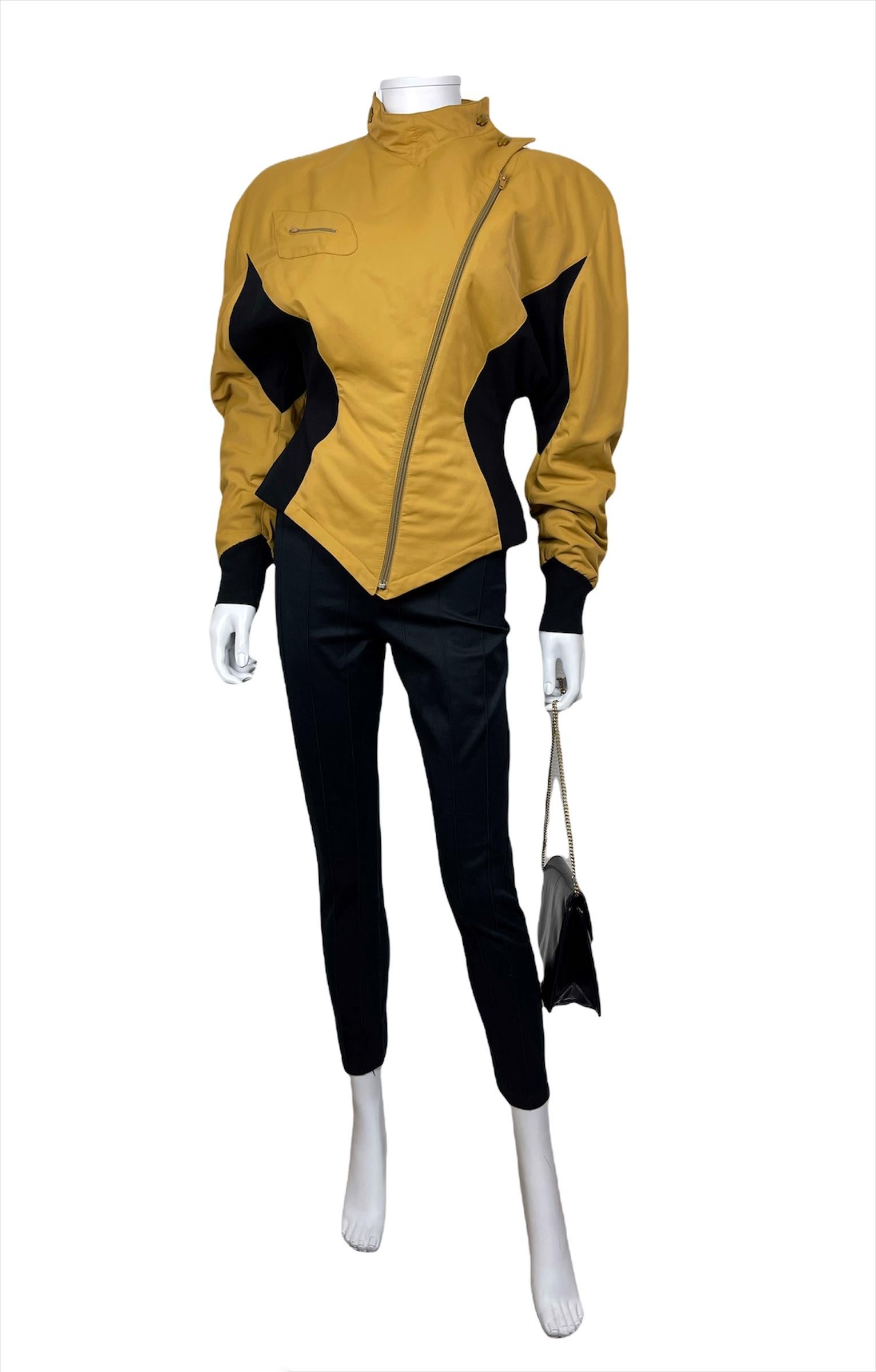 THIERRY MUGLER Activ, circa 86. Made in Italy. 
Two-tone mustard yellow and black jacket with wide shoulders and cinched waist. Diagonal zipper. Collar finished with stylized yellow buttons. 45% polyamide 55% polyester. 
Tag size is 42IT,