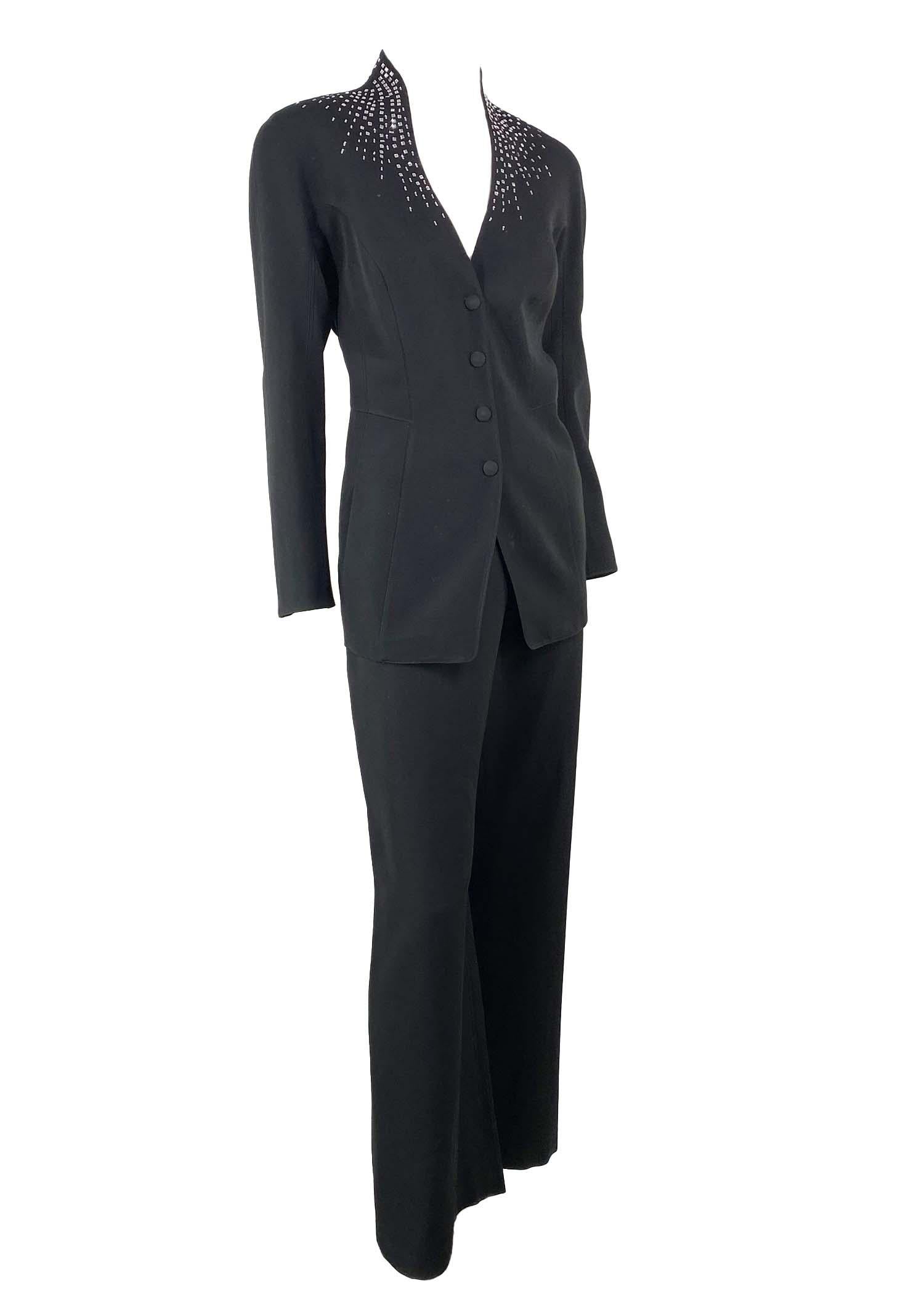 Presenting a rhinestone Thierry Mugler pantsuit, designed by Manfred Mugler. From the 1990s, this suit features masterful design and tailoring. The blazer features a stand up collar, snap closures, and rhinestones around the neck and nape of the