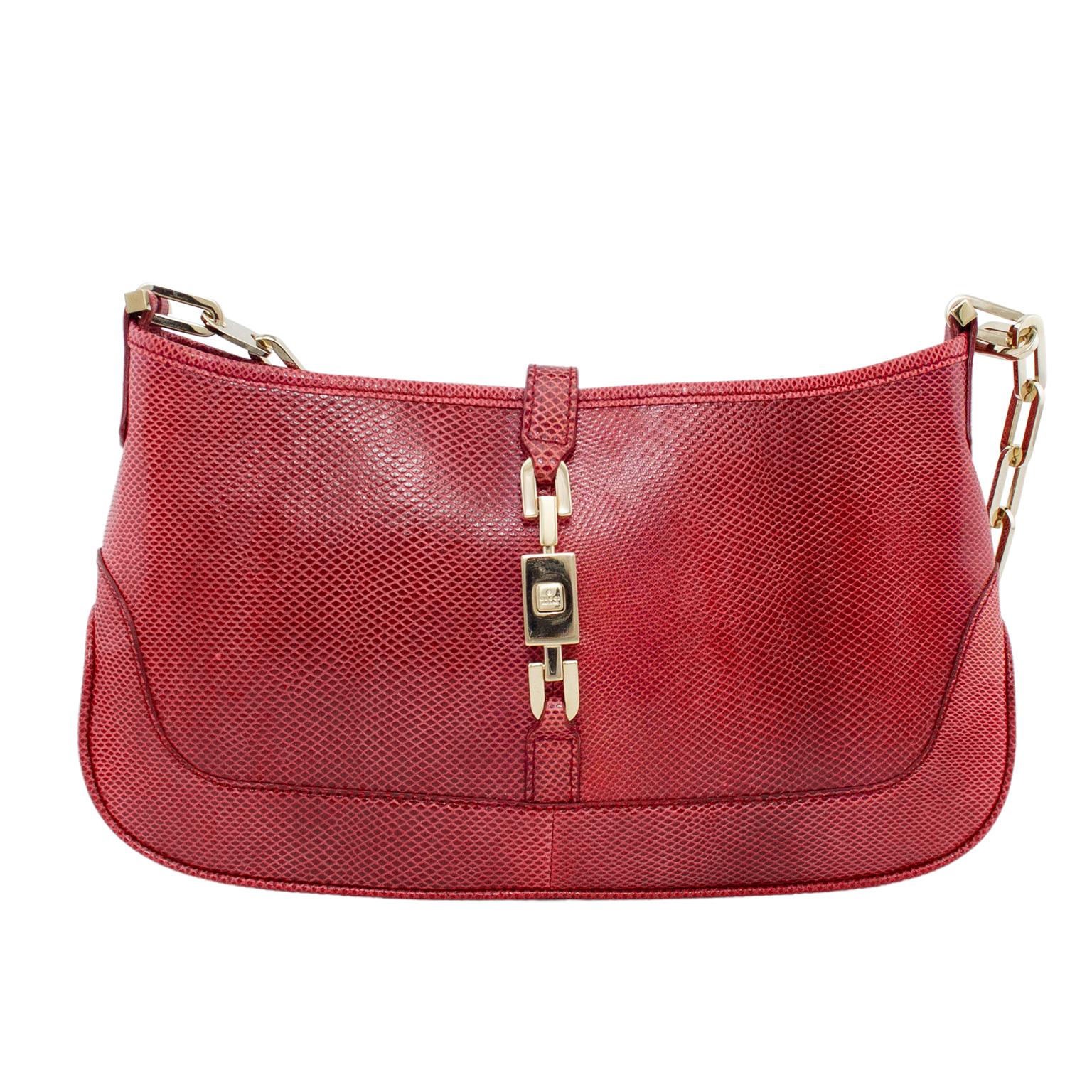 From Tom Fords era at Gucci, this is the mini size Jackie O Gucci bag. Gradient cranberry red reptile effect with silver metal chain link handle. Silver tone metal slide lock closures with a Gucci logo engraved button that you press to release.