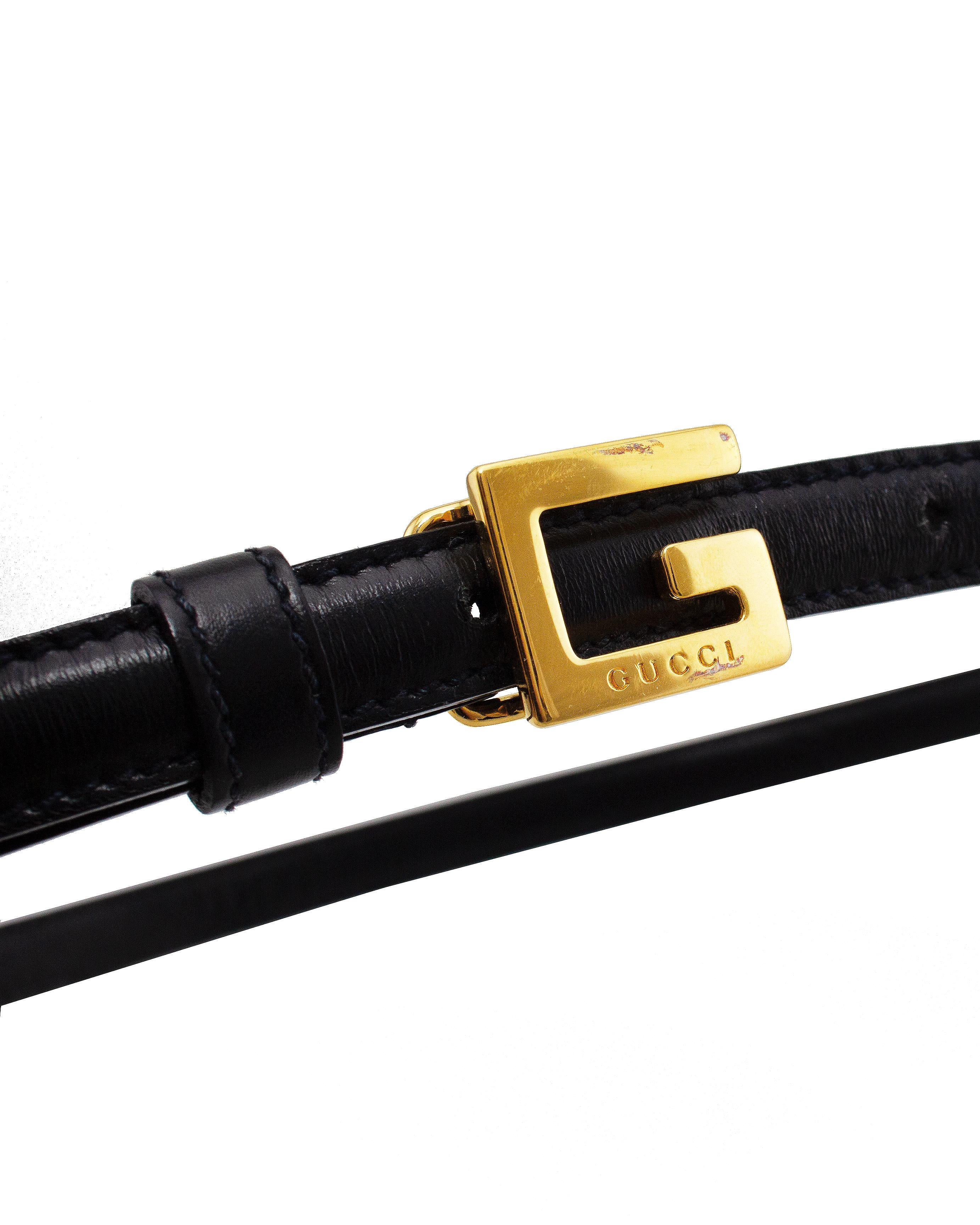 Timeless Tom Ford for Gucci belt from the mid 1990s. Thin black leather with tonal black top stitching and a small square G gold tone metal buckle. Buckle is engraved with Gucci along the bottom. Hook clasp with three size settings: 30.5