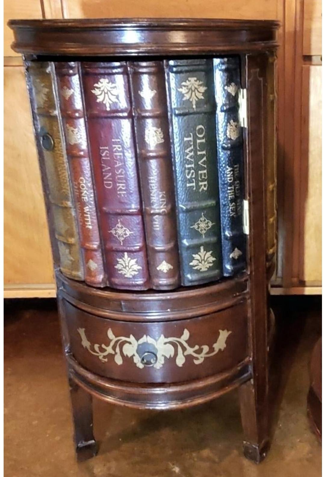 Vintage trompe l'oeil/ faux book round side table.
In the romantic, figurative style of Maitland Smith. 
Hand tooled leather bindings with gold writing adorn the exterior and also adorn the door.
Small drawer with pull.
Door also has a brass ring