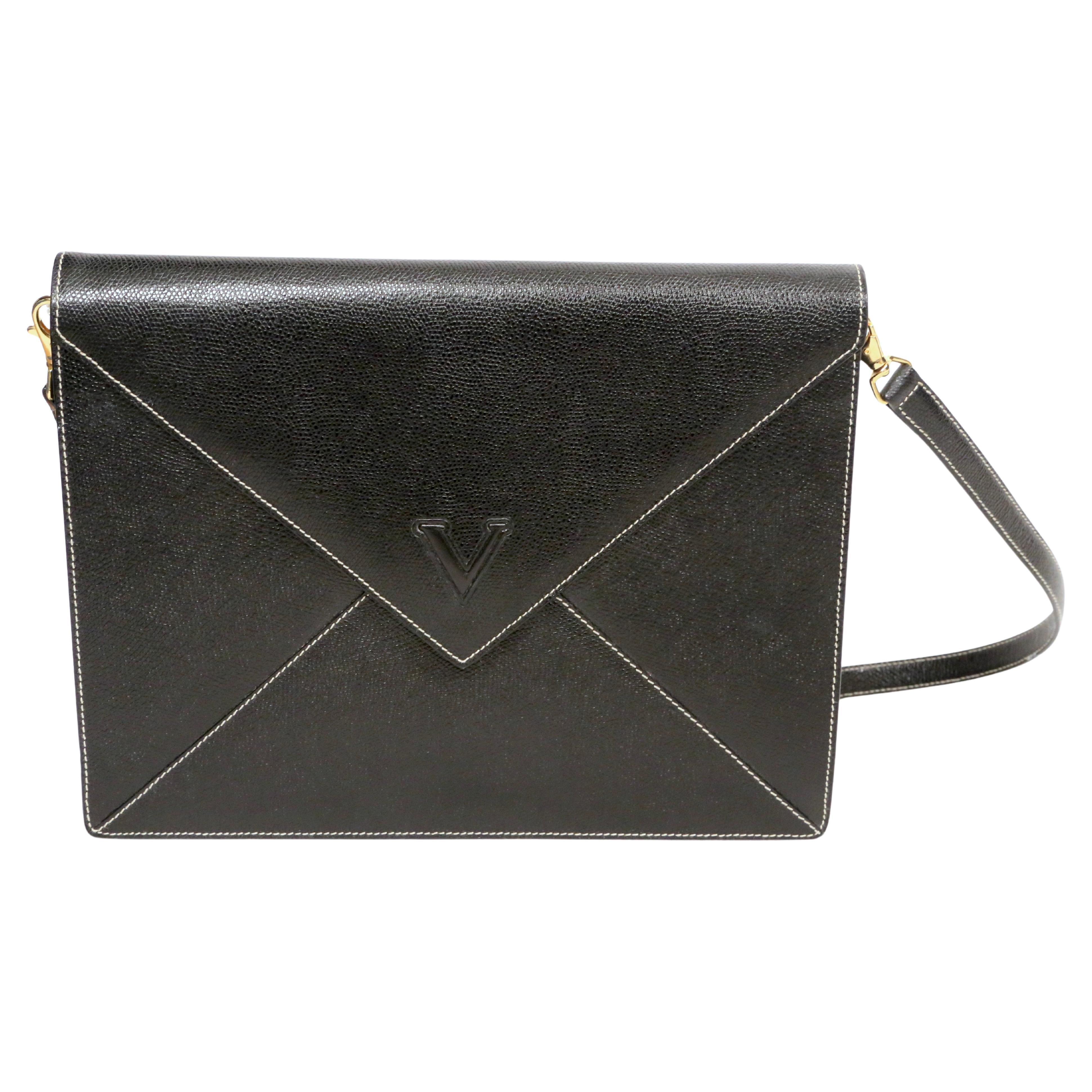 Black textured leather convertible bag in the shape of an envelope designed by Valentino dating to the 1990's. Strap is completely removable. Gold hardware. Off-white top-stitching. Bag measures approximately 11.75