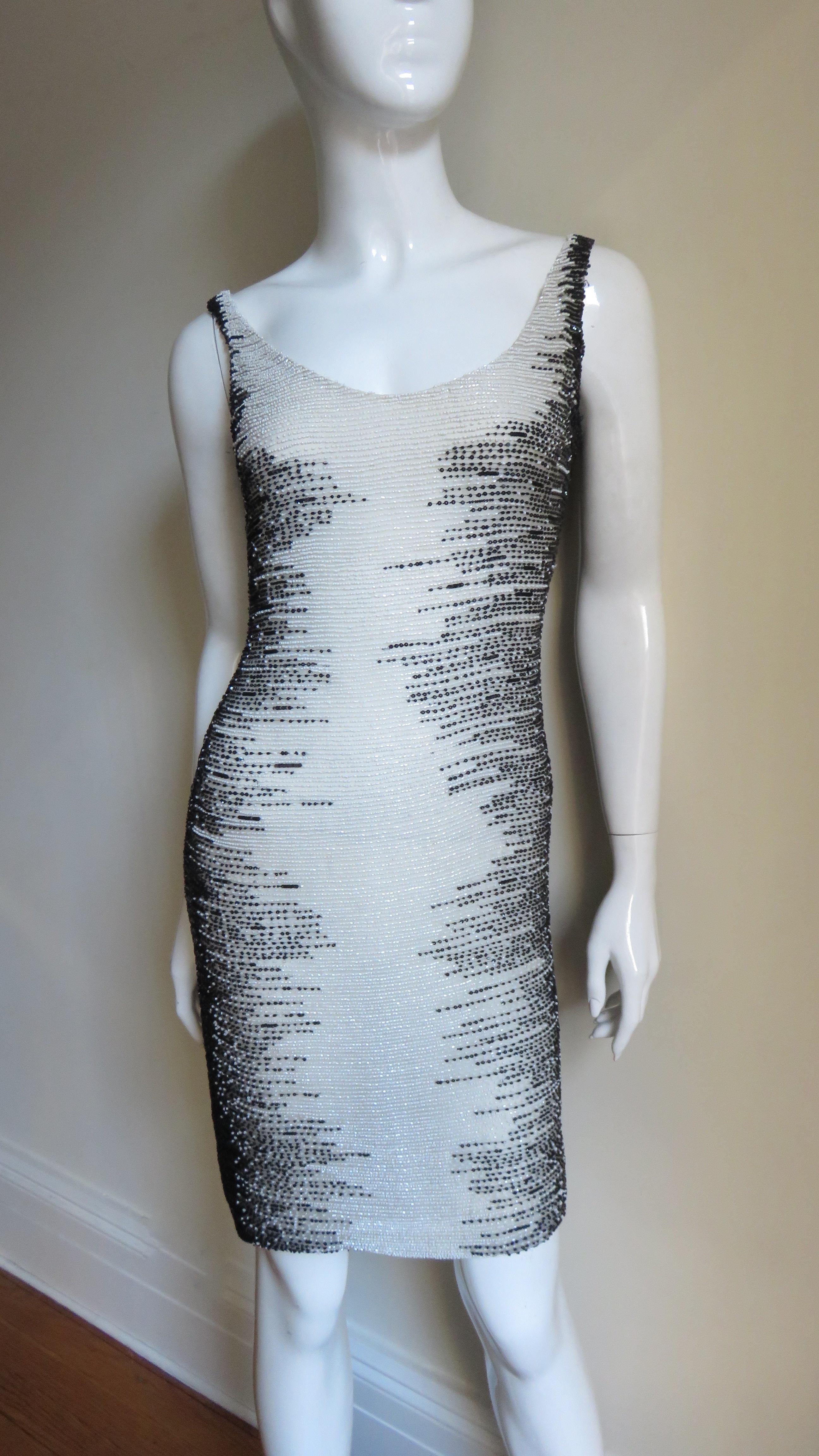 A fabulous off white silk dress completely beaded in black and off white from Valentino Boutique.  It has a scoop neckline front and back skimming the body and is completely covered in rows of off white and black fine glass beads with the black at