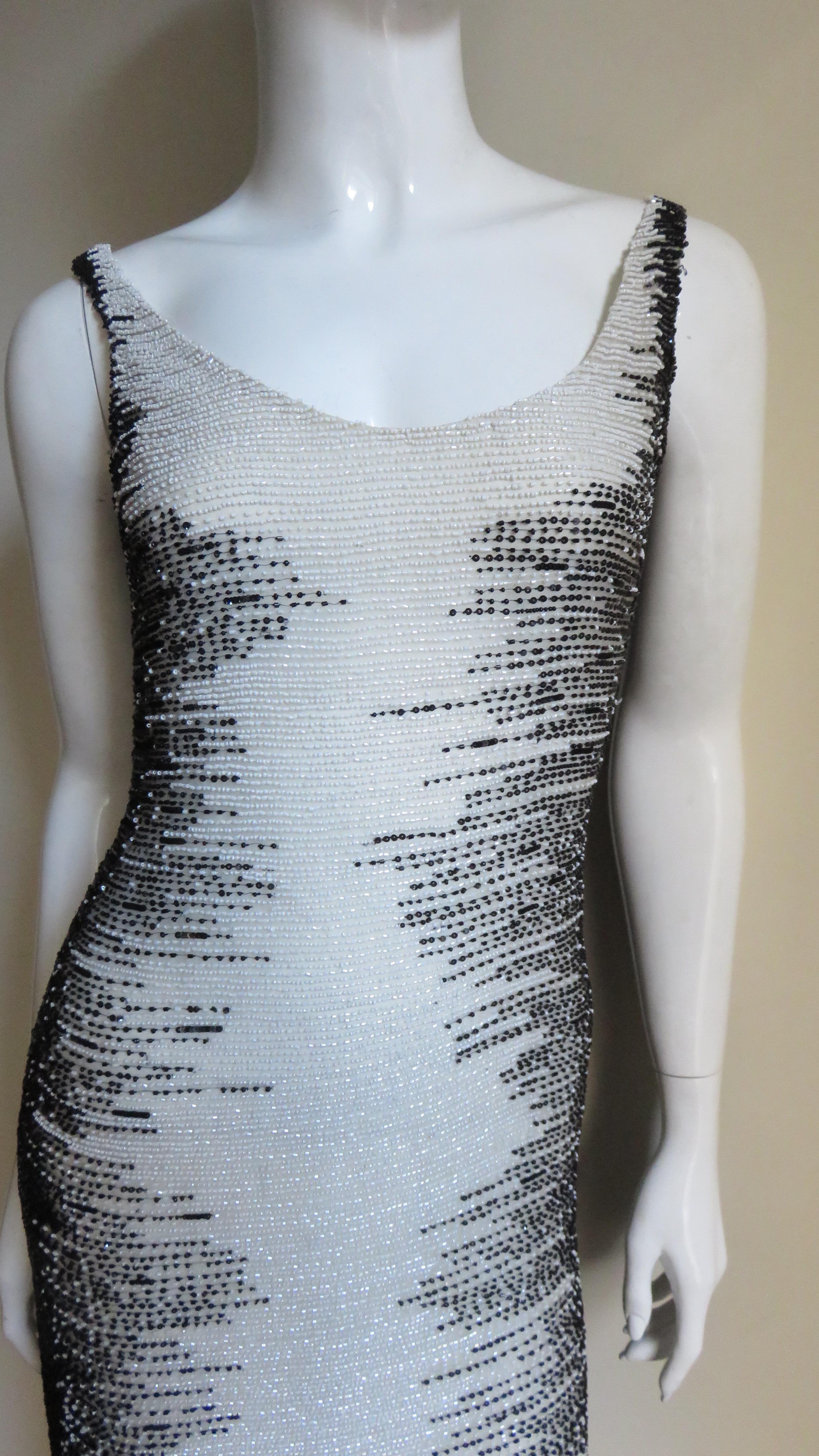 A fabulous off white silk dress completely covered in black and white glass beads from Valentino Boutique.  It is sleeveless with a scoop neckline front and back, skims the body and is completely covered in horizontal rows of white fine glass beads
