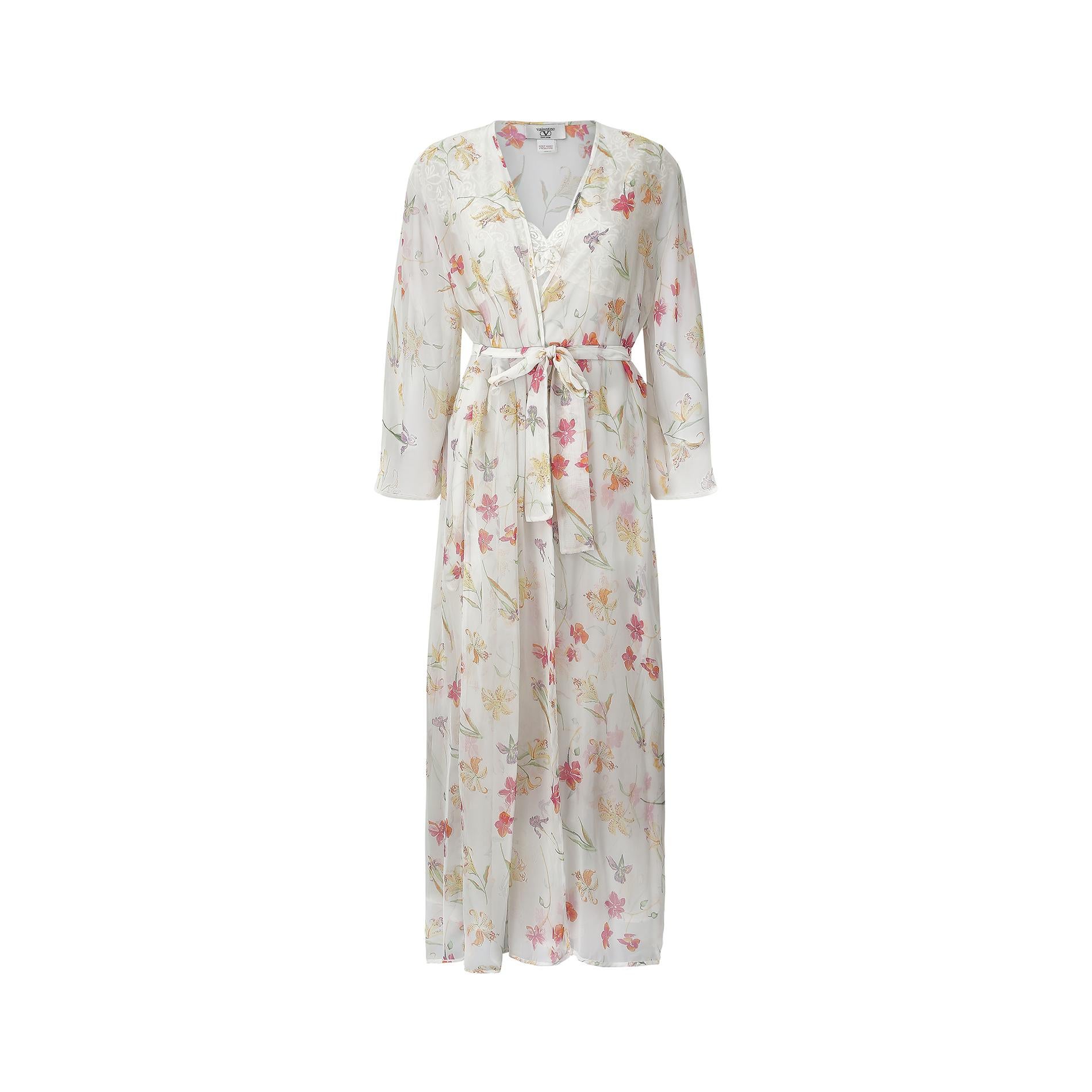 This 1990s Valentino lingerie set features a floral and lace trimmed slip dress and a matching dressing gown with floaty sleeves, both in a beautifully soft Georgette crepe fabric. The dress has an unlined lace bust, with a deep V to both front and