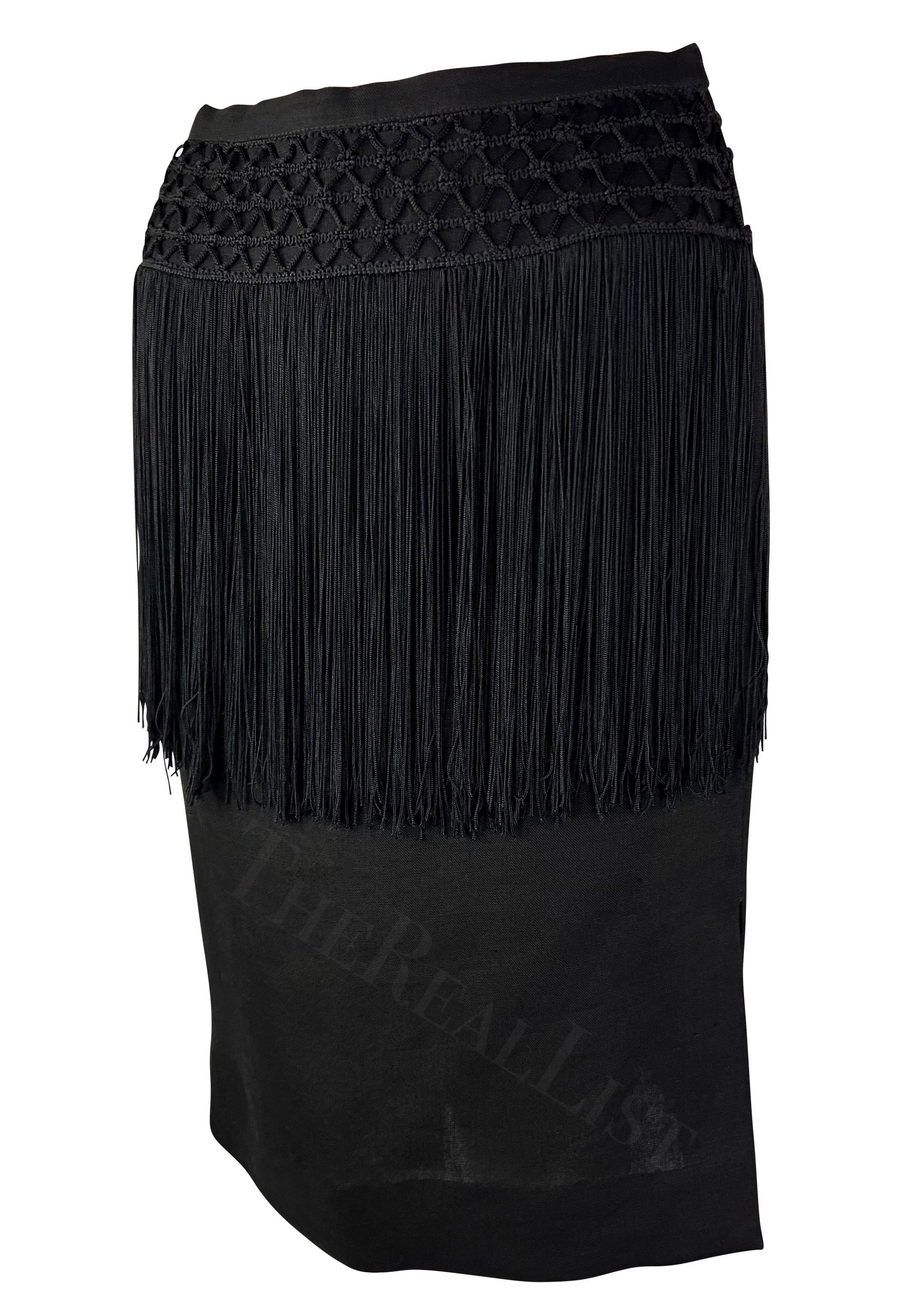 Te presentamos una falda lápiz Valentino Garavani de lino negro. De principios de los 90, esta falda está confeccionada en lino y presenta una abertura en un lado y detalles de ganchillo y flecos que caen en cascada por la cintura. Mejora tu