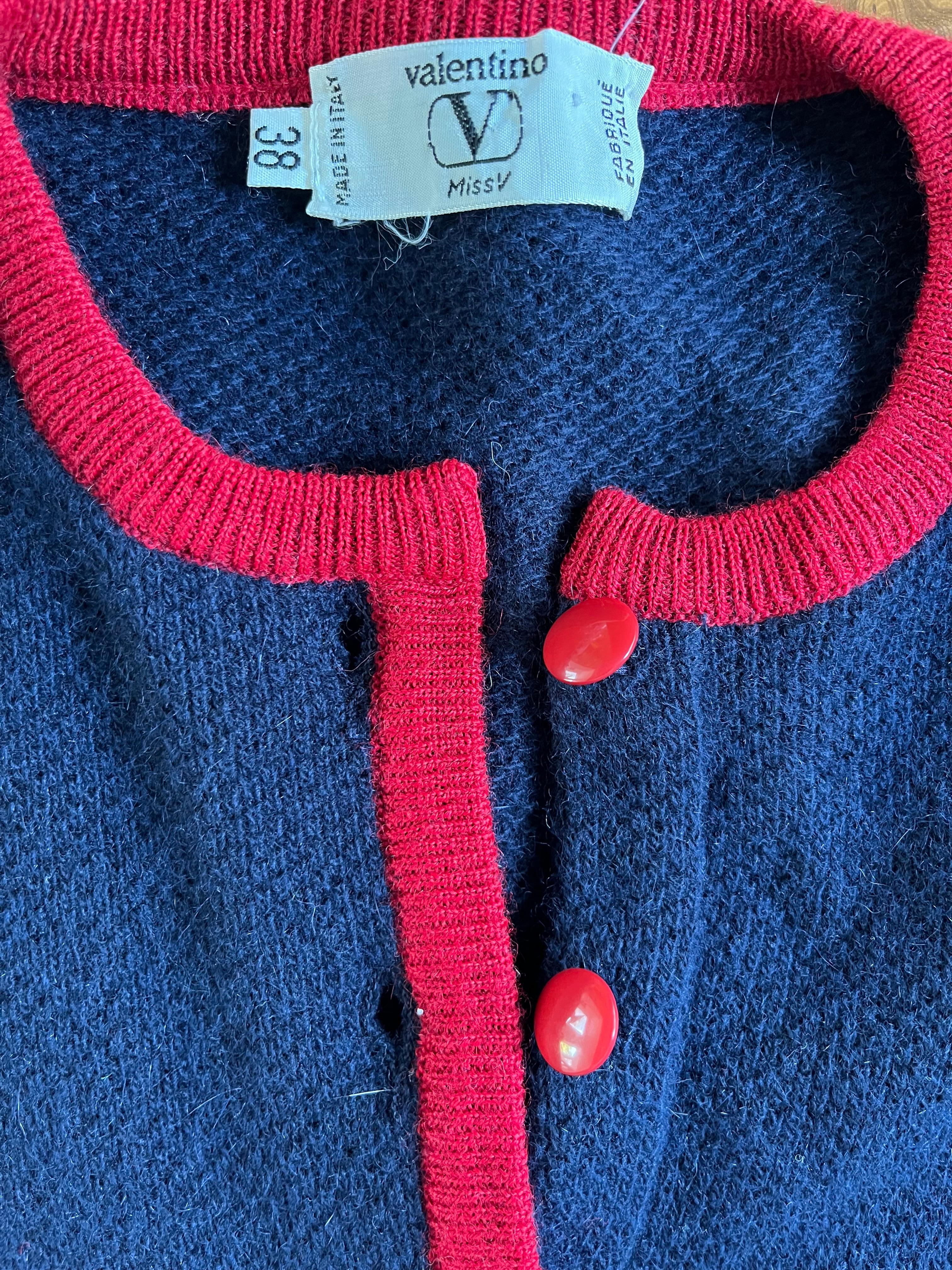 Pull en laine d'agneau et angora marine V.I.I. Valentino des années 1990.  Tricot double épaisseur avec des détails rouges autour du col, 3 boutons acryliques rouges et des détails rouges sur la couche intérieure de la zone de la taille.  Il semble