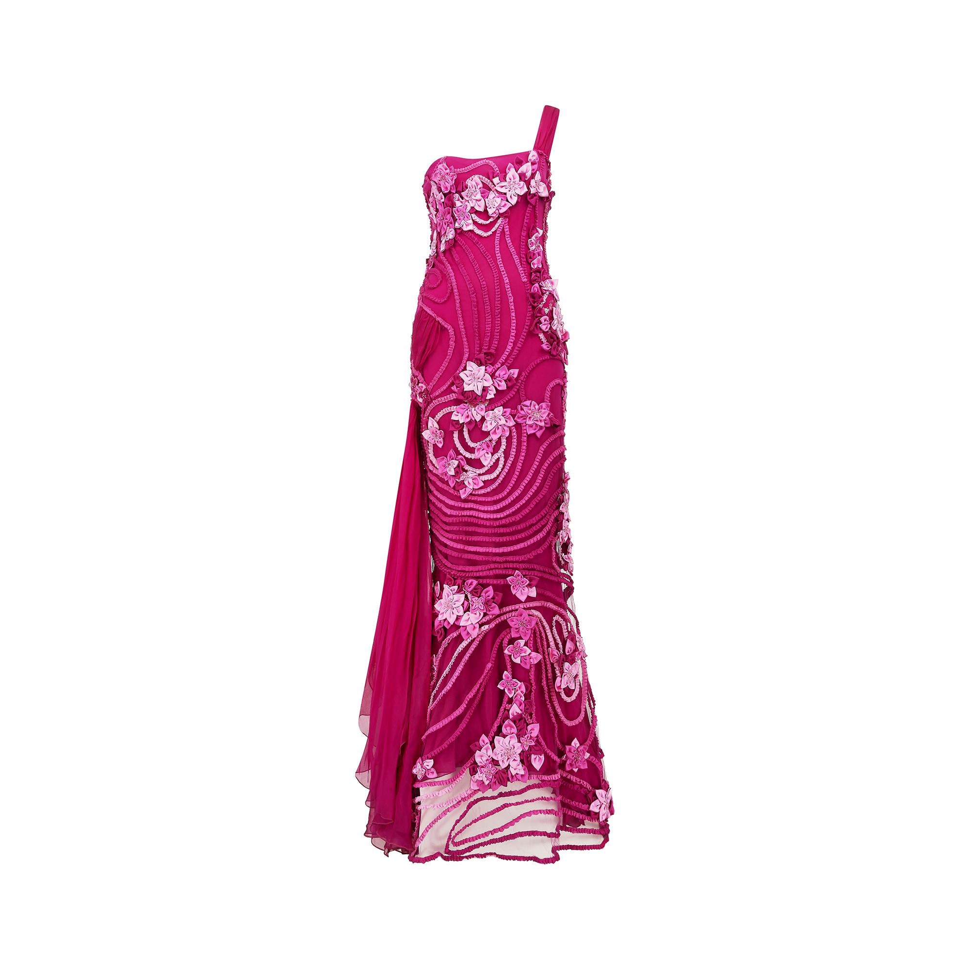 This is an exceptional Y2K Valentino Garavani dress, probably Cruise Collection 2000, when the eponymous designer himself was the creative director. It is a lavish concoction of cerise pink ribbon work and has an asymmetric left hand silk chiffon