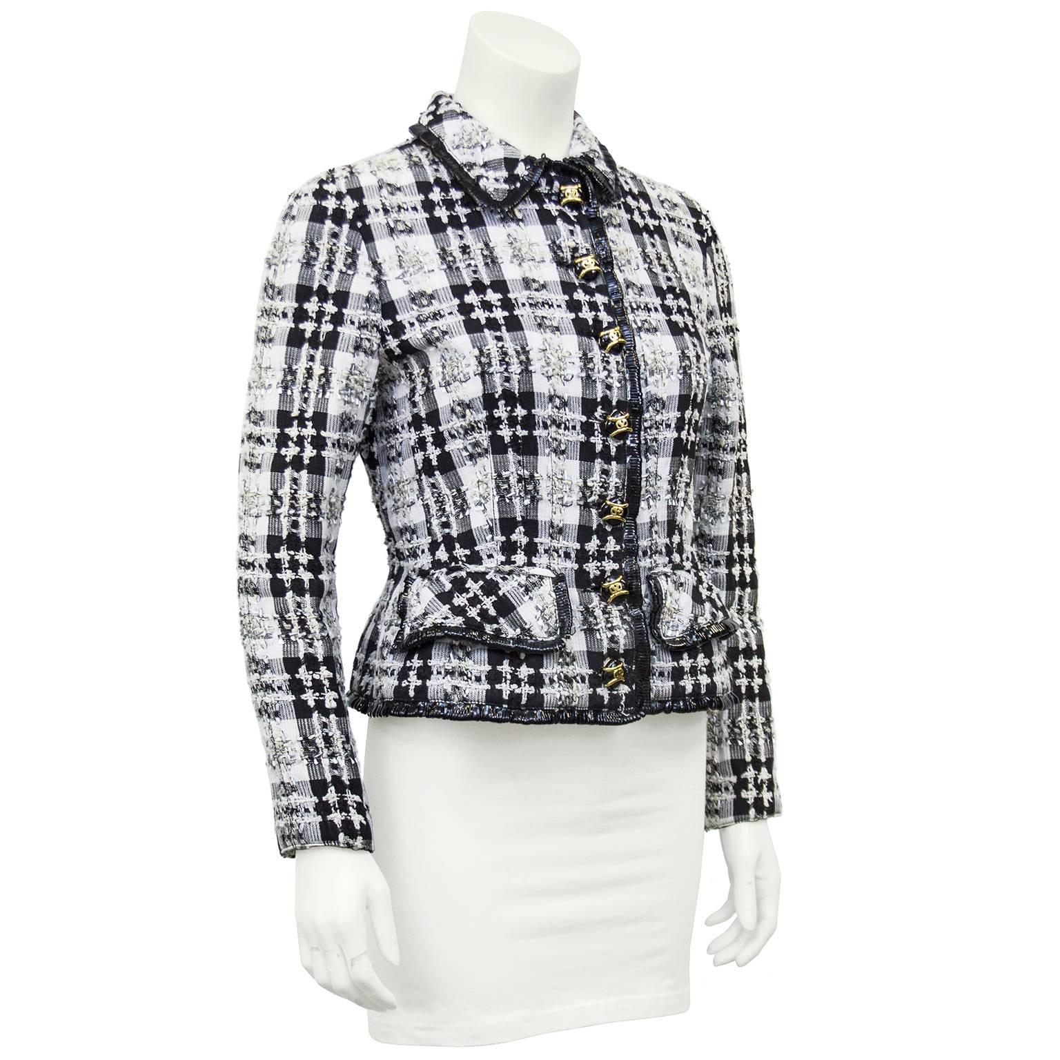 1990s Valentino black and white buffalo plaid jacket with tweed trim throughout. Black vinyl looped fringe trim at collar, flap pockets and hem. Large black diamond shaped buttons with gold tone V logo details. Fitted throughout, cinched at waist.