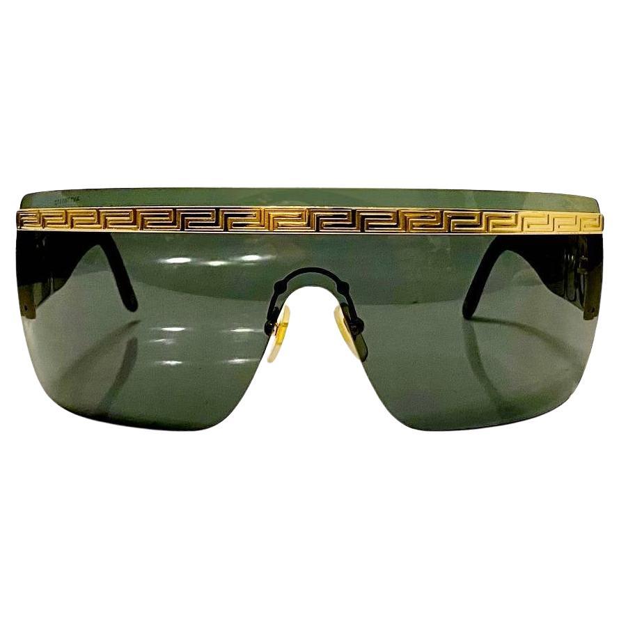 Make a statement with these chic 1990s Versace Medusa Medallion Mask Sunglasses. Crafted with black resin and luxe gold and black frames, these Italian-made sunglasses combine sophistication and style. Perfect for adding a touch of exclusivity to