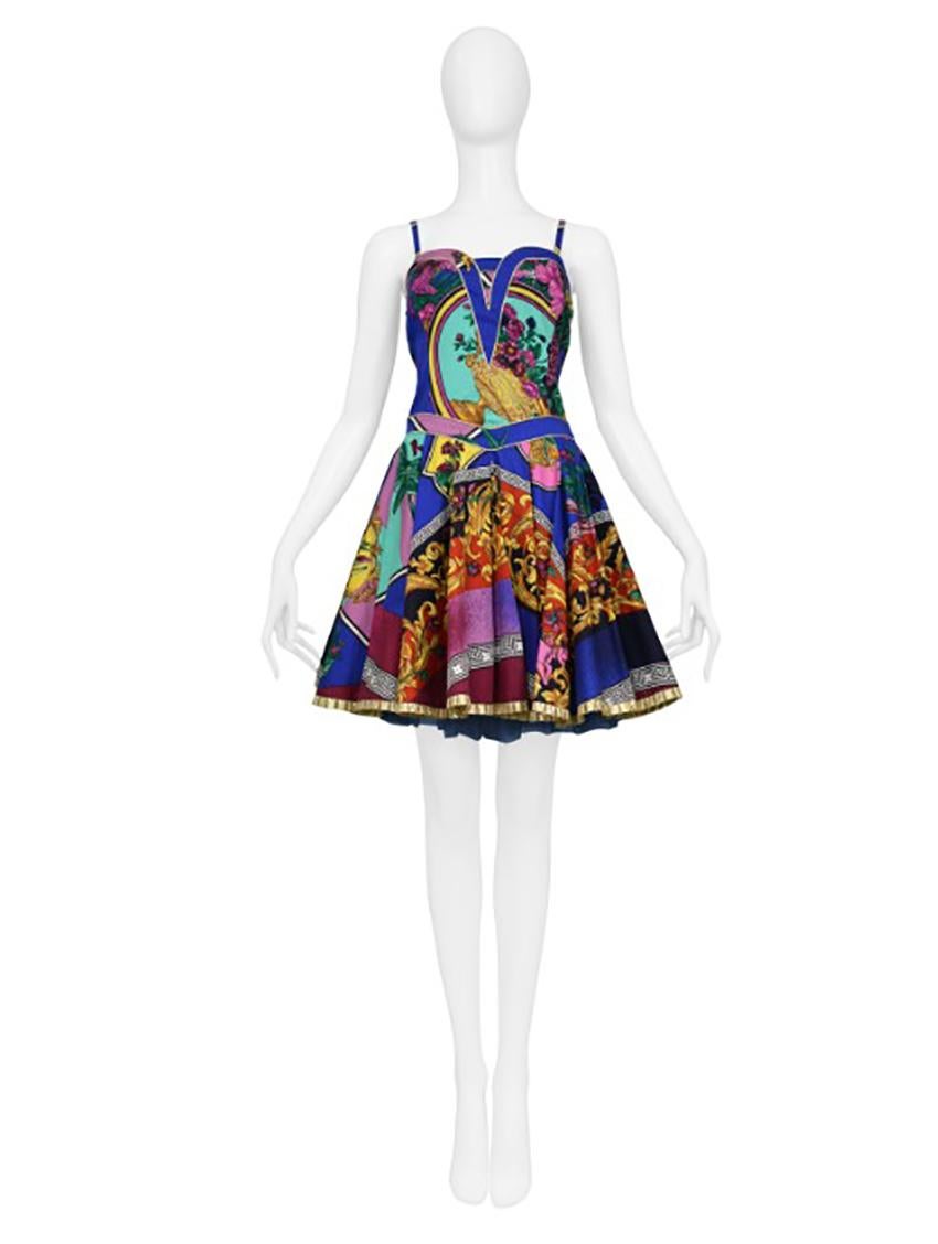 VERSACE 

Iconic Gianni Versace Jeans Couture party frock with neo-Rococo print. Dress features a gold crinoline under skirt. This piece has never been worn and came with original tags. Collection 1992.

An amazing dress by Versace. Jewl tones,
