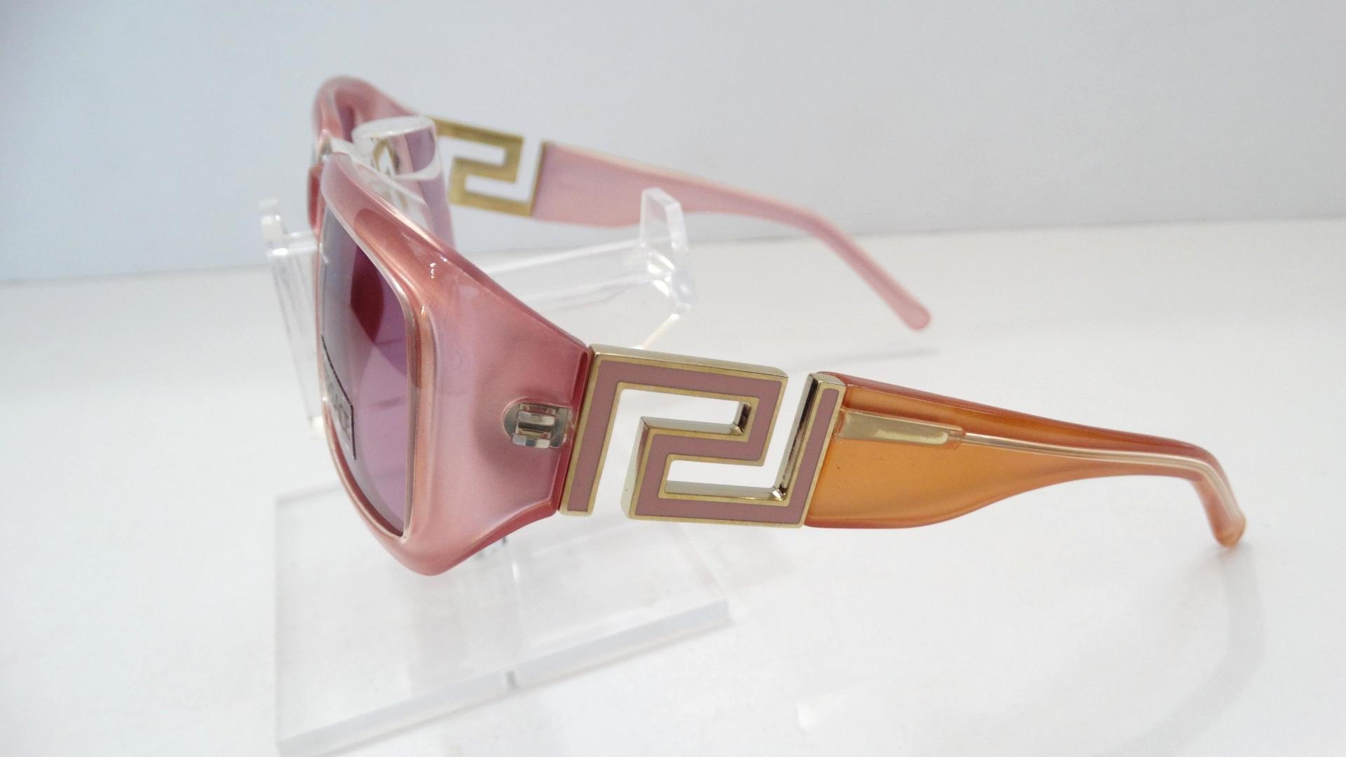 The Perfect Sunglasses For This Summer! Circa 1990s, these dead stock Versace rectangular sunglasses are a semi clear baby pink color. Feature pink tinted lenses and the iconic Versace Greek key as a link on the arms. Greek key is matte pink with