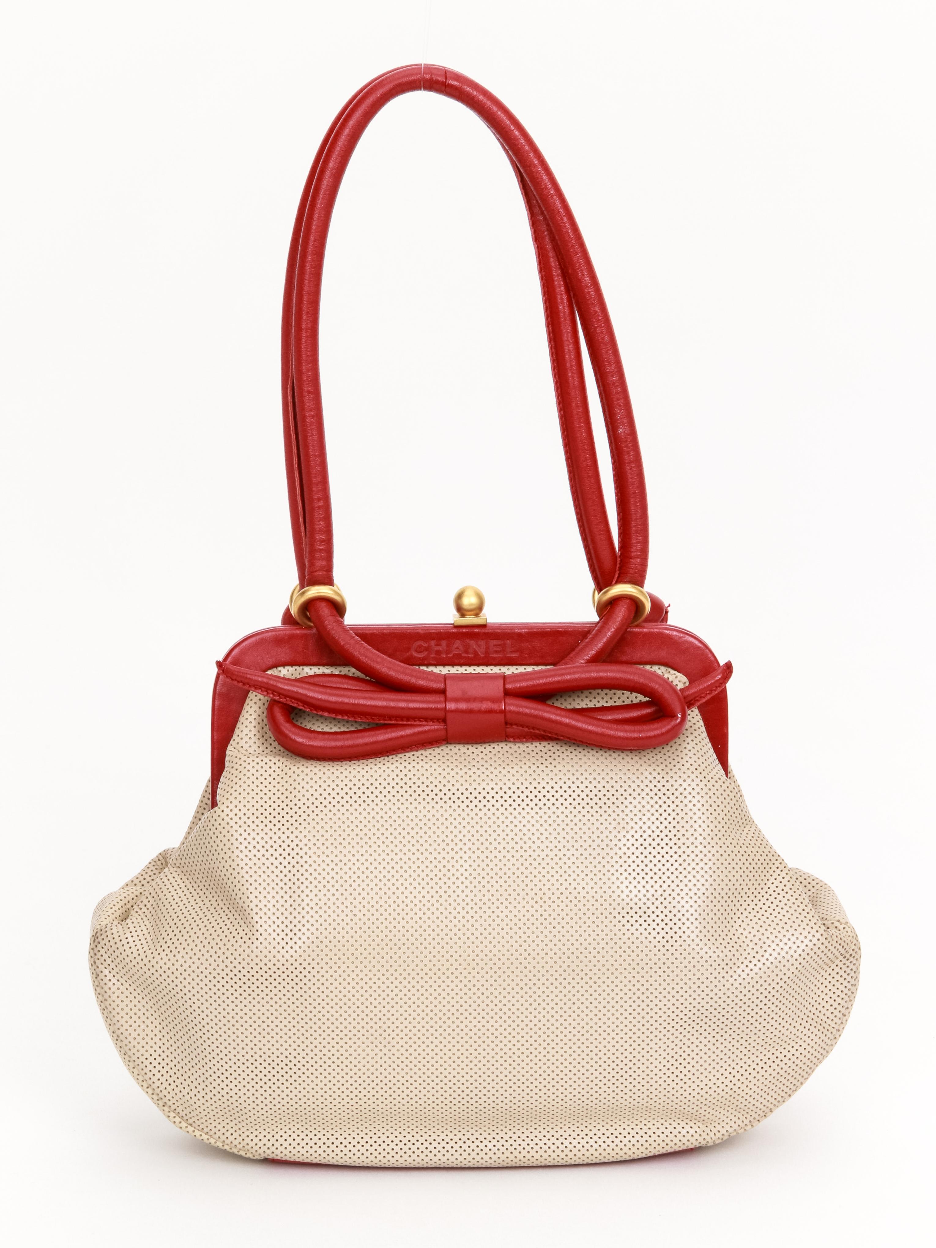 Chanel 90s beige perforated vintage bag in beige perforated leather and red leather trimming. Front center bow, satin gold hardware. Shoulder drop 8