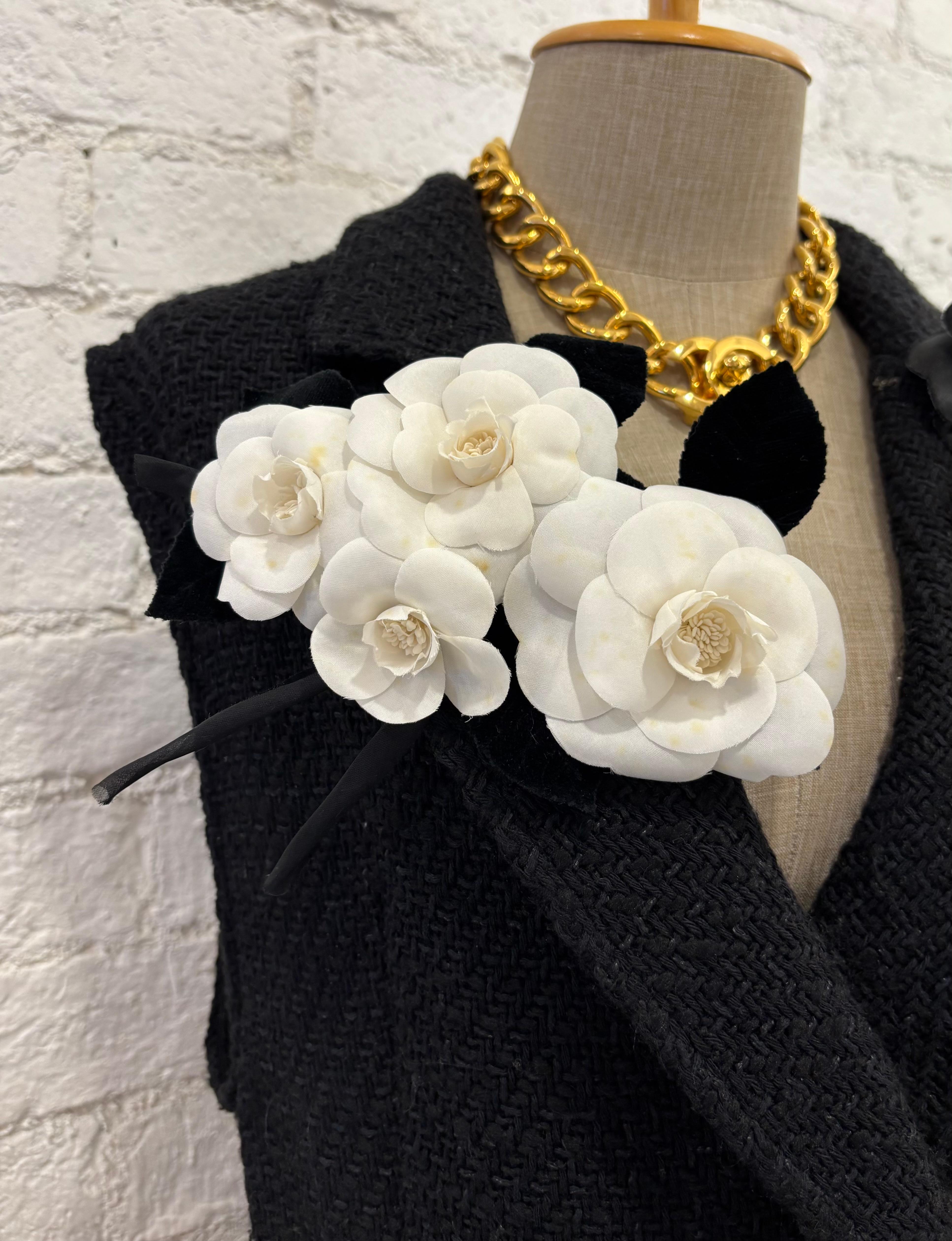 Questa spettacolare spilla vintage di Chanel è composta da quattro camelie di seta bianca ornate da foglie di velluto nero e strisce di chiffon sul retro. Timbro CHANEL made in France. Misura circa 20 x 13 cm. Viene fornito con la scatola bianca di