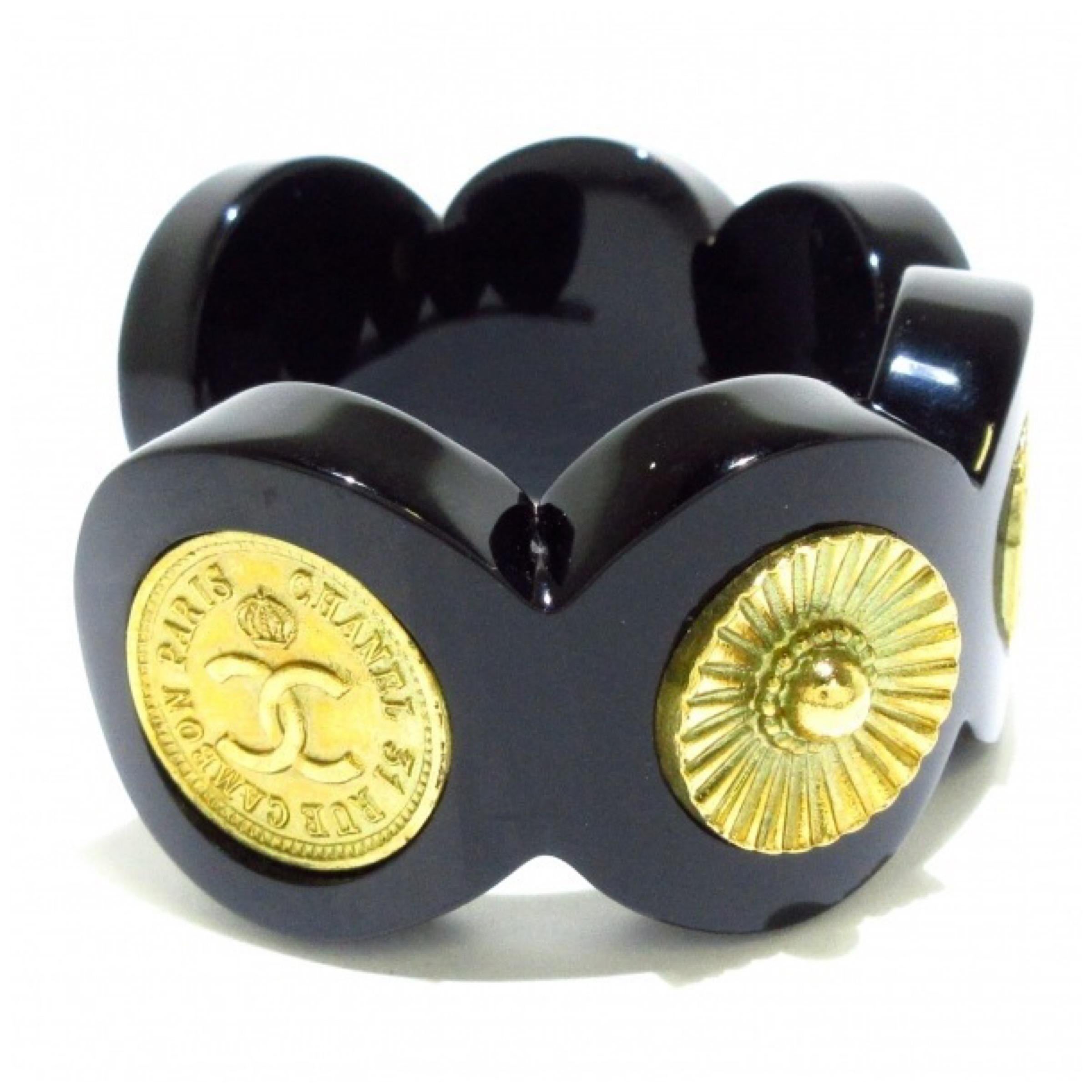 Vintage Chanel black resin cuff bracelet featuring six Chanel’s motifs including a very rare CoCo elephant coin. Stamped CHANEL 28 made in France. Inner circumference measures approximately 16 cm. Comes with box.

Condition: Very good vintage
