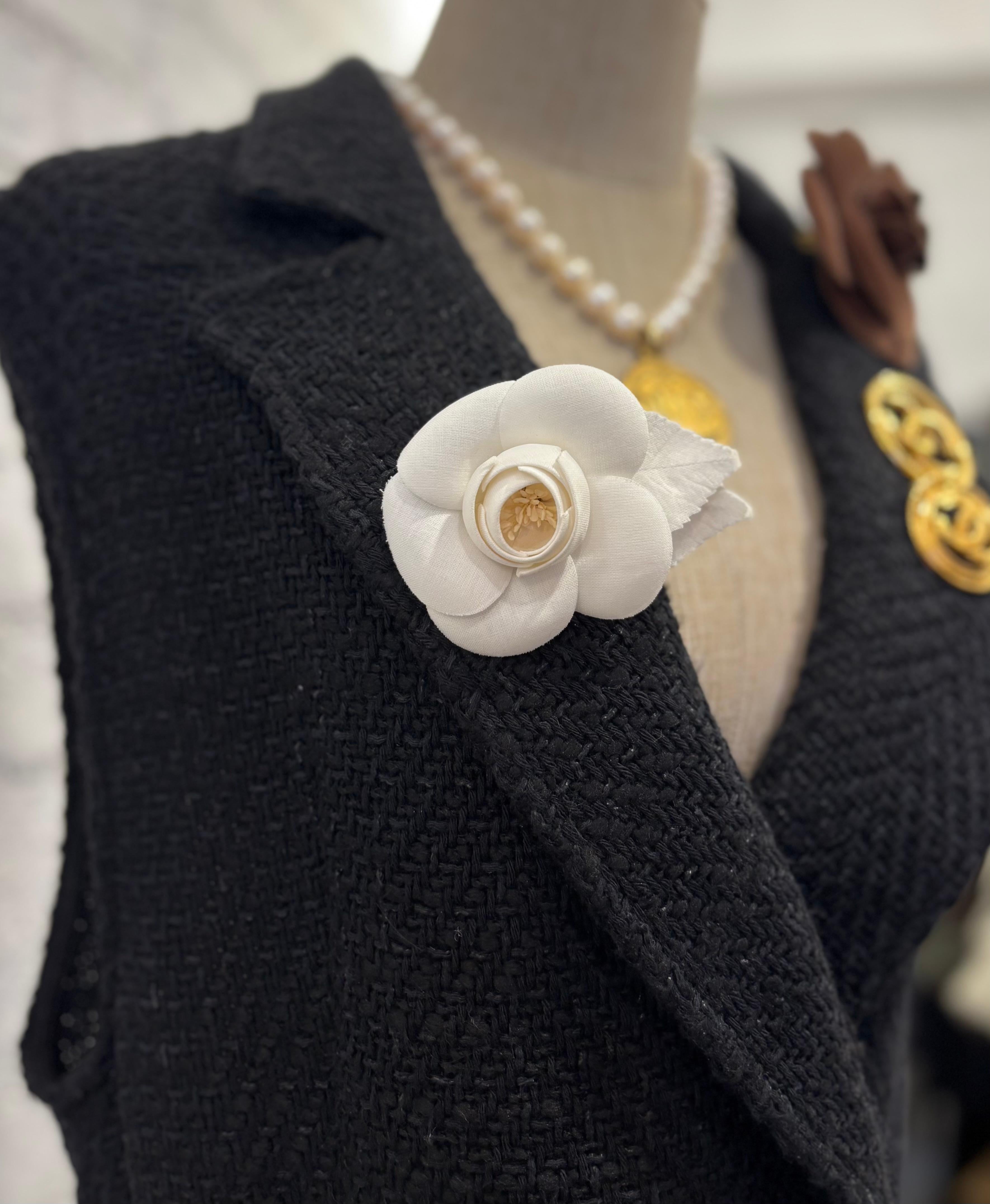 Este broche camelia vintage de CHANEL está confeccionado en algodón de color blanco adornado con dos hojas del mismo tejido. Estampado CHANEL made in France. Mide aproximadamente 7 x 9 cm. Viene con caja.

Estado: Excelente estado vintage con signos