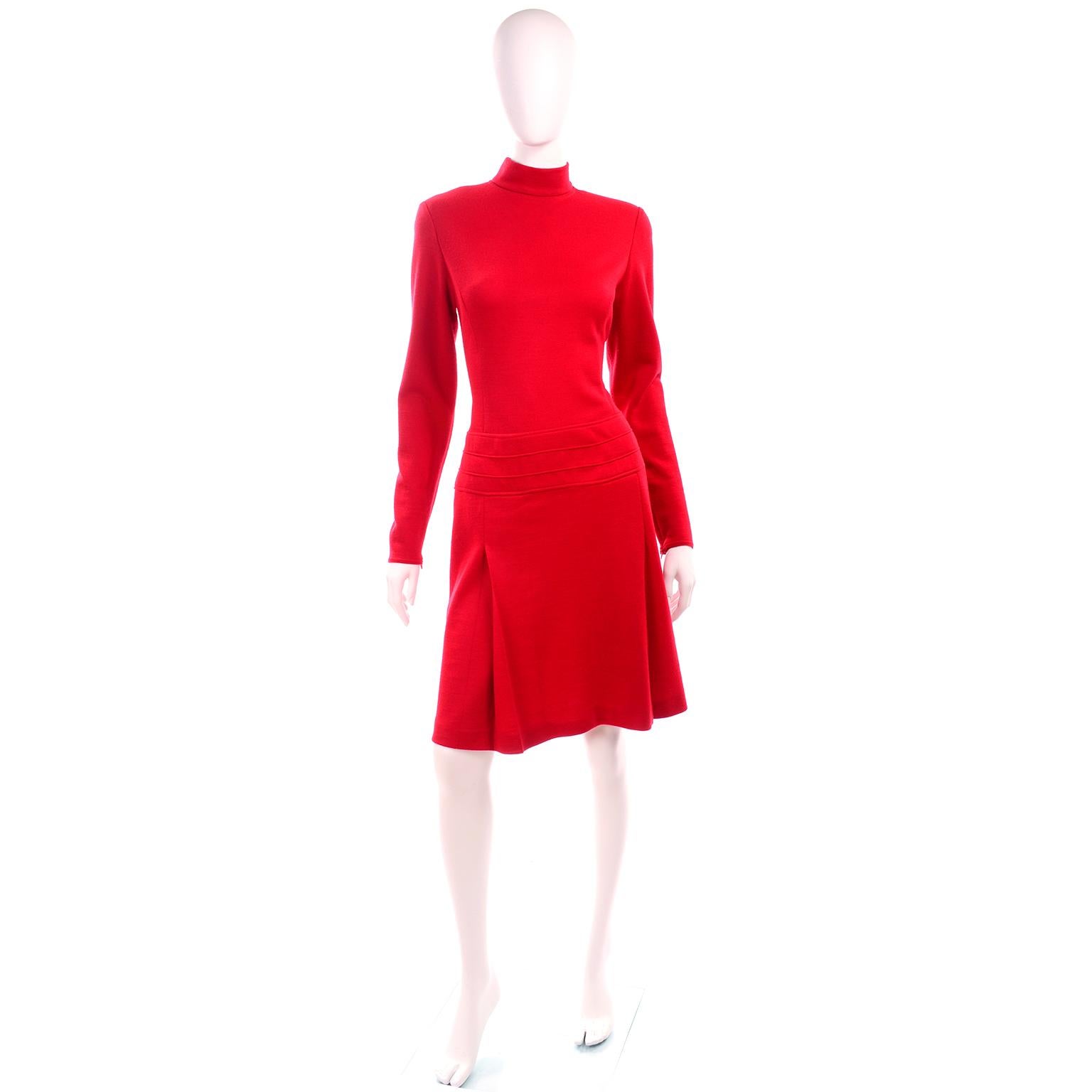 This is a vintage 1990's State of Claude Montana cherry red wool blend knit day dress with a mock t neck, inverted pleated skirt, and structured seam details at the drop waistline. This easy to wear dress has long sleeves with metal zippers at the