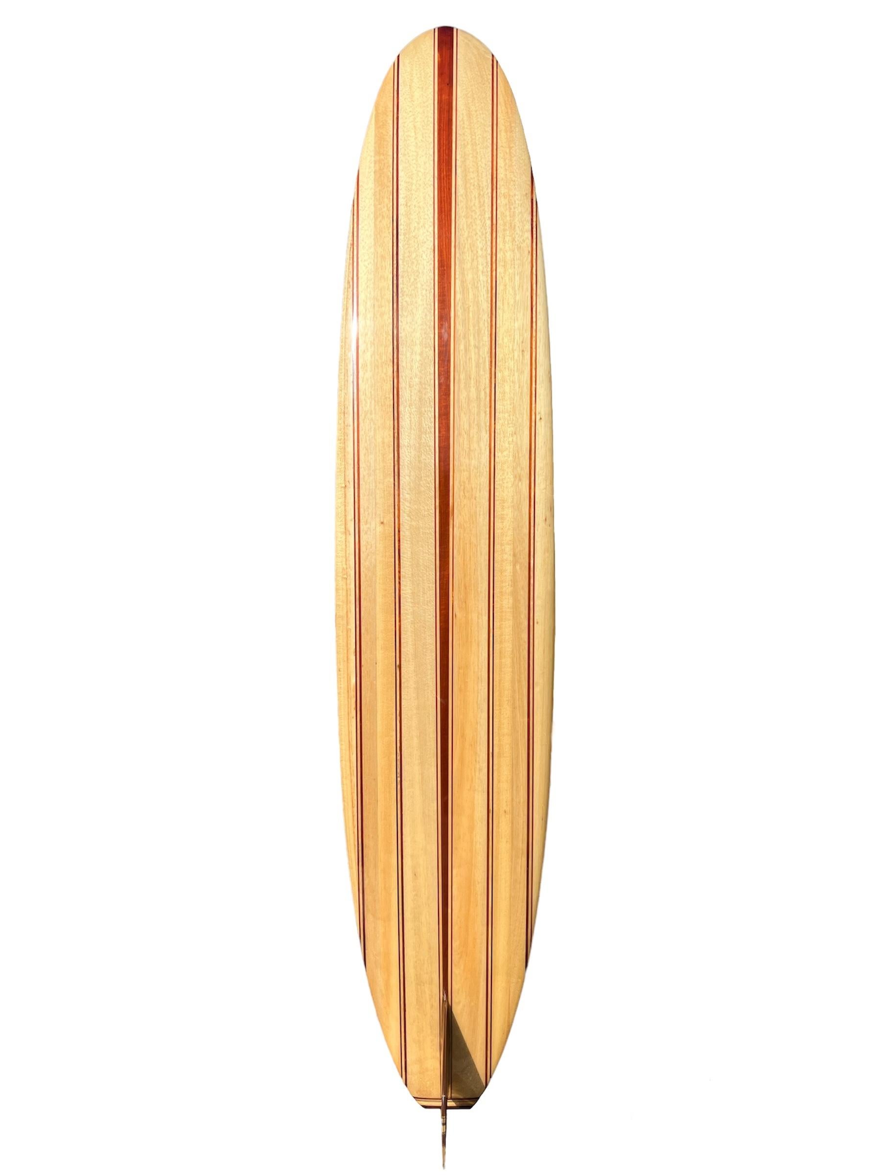 Mid-1990s Velzy balsawood longboard shaped by the late Dale Velzy (1927-2005). Features an incredible 11-stringer design with a stunning 29 piece wooden fin and complimentary 7 piece tail-block. The most intricate example of a vintage Dale Velzy