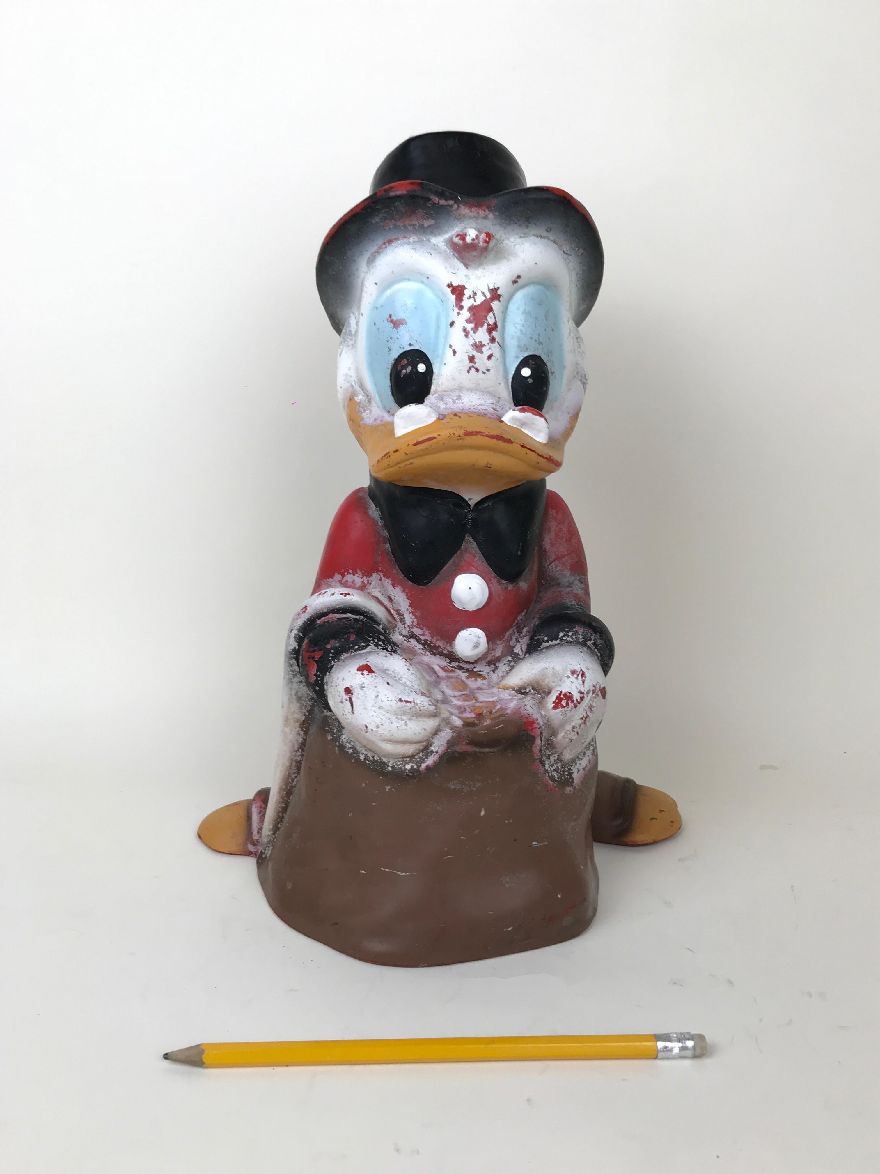 Vintage plastic garden sculpture of Uncle Scrooge. 
Made for Disney by Austrian maker Celloplast in the 1990s.

Marked Disney on the bottom back of the sculpture and CELLOPLAST ade in Austria on bottom.
