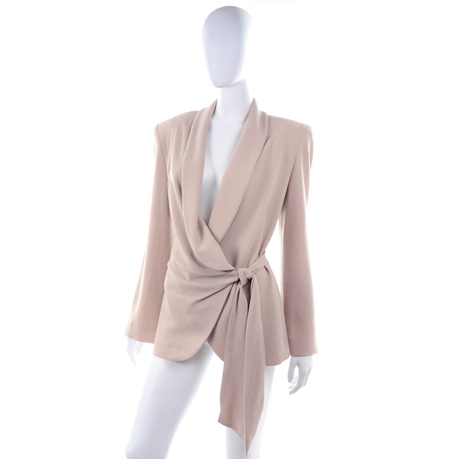 This is a deadstock Donna Karan 1990's vintage tan / beige wool blazer that ties in the front with an attached sash.  The jacket closes with a single button on the inside, giving it a wrap effect.  We love the way it is draped so beautifully and the