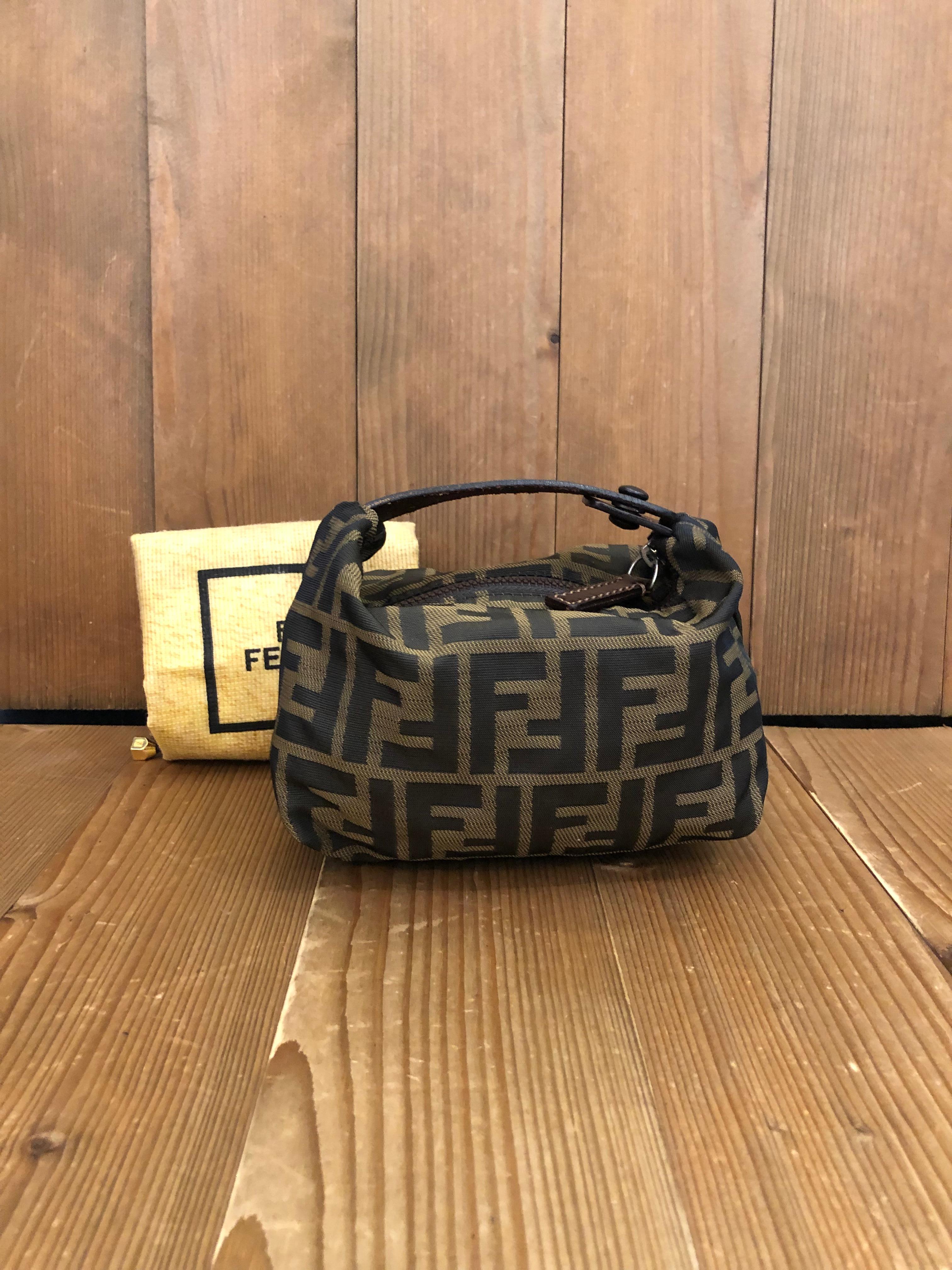 Vintage Fendi mini pouch handbag in Fendi's iconic brown Zucca jacquard. Zipper top with snap fastening closure opens to an un-lined interior. Made in Italy. Measures 6.5 x 4 x 4 inches (fits plus-sized iPhone). Comes with dustbag (slightly