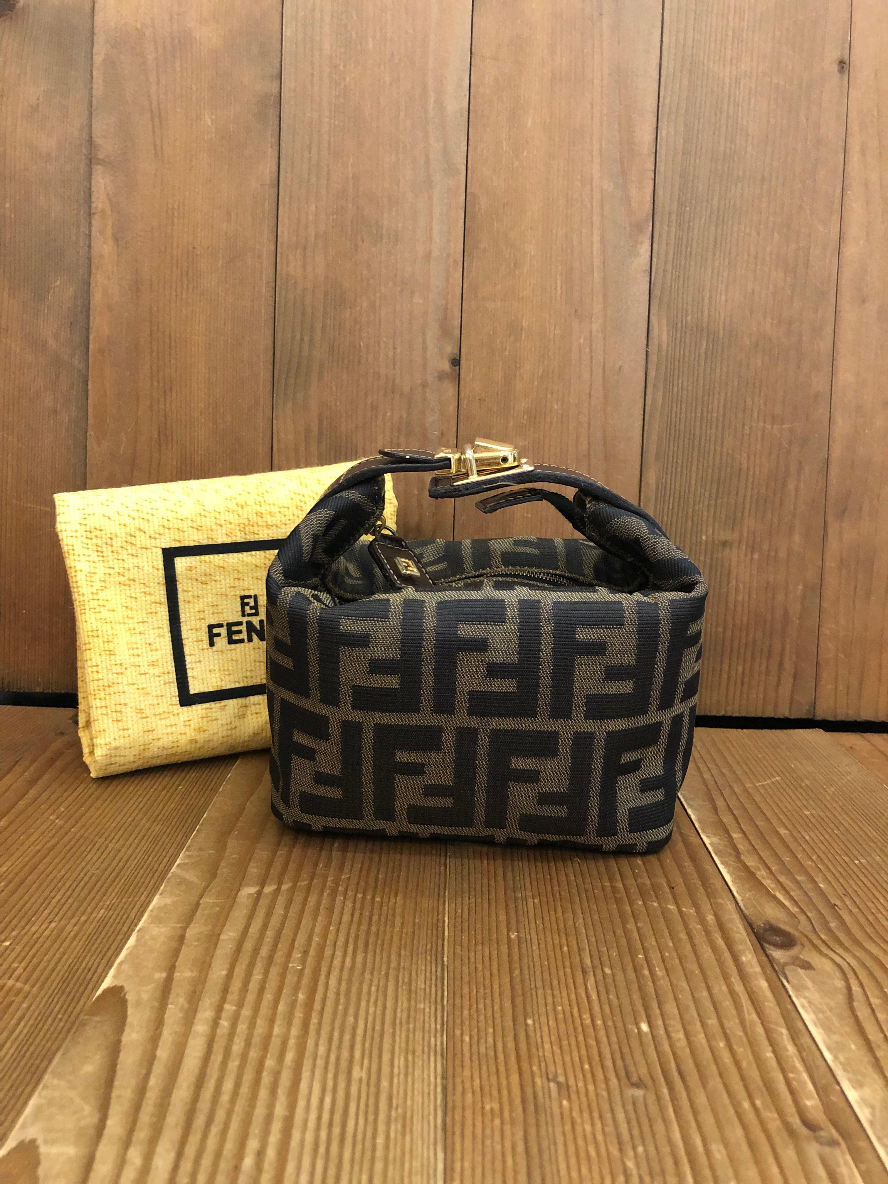 Vintage Fendi mini vanity pouch in Fendi's iconic Zucca jacquard featuring gold toned buckled handle. Made in Italy. Measures 6 x 5 x 3.75 inches (fits plus-sized iPhone)

Condition: Minor signs of wear. Interior fully re-lined

Outside: Minimal