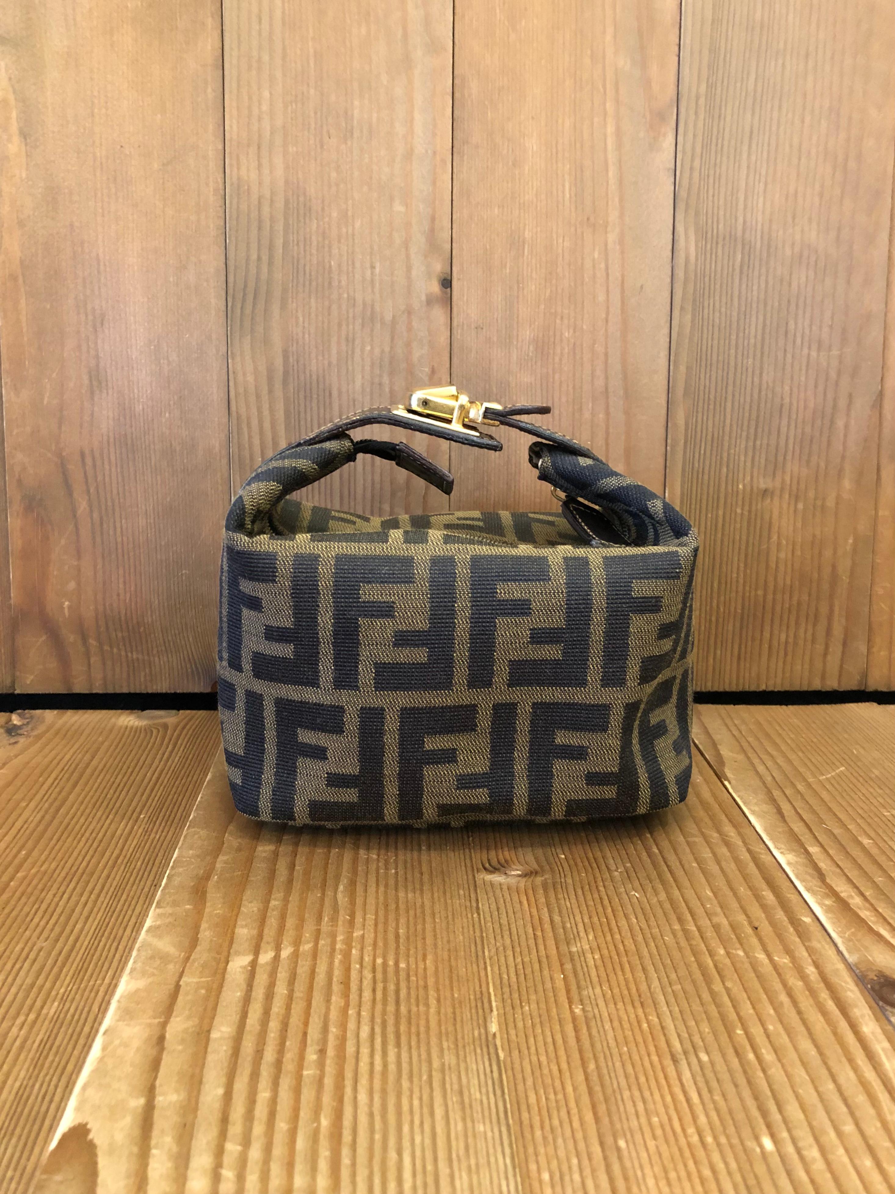 Vintage Fendi mini vanity pouch in Fendi's iconic Zucca jacquard featuring gold toned buckled handle. Made in Italy. Measures 6 x 5 x 3.75 inches (fits plus-sized iPhone)

Condition: Good vintage condition with minor signs of wear. Interior fully