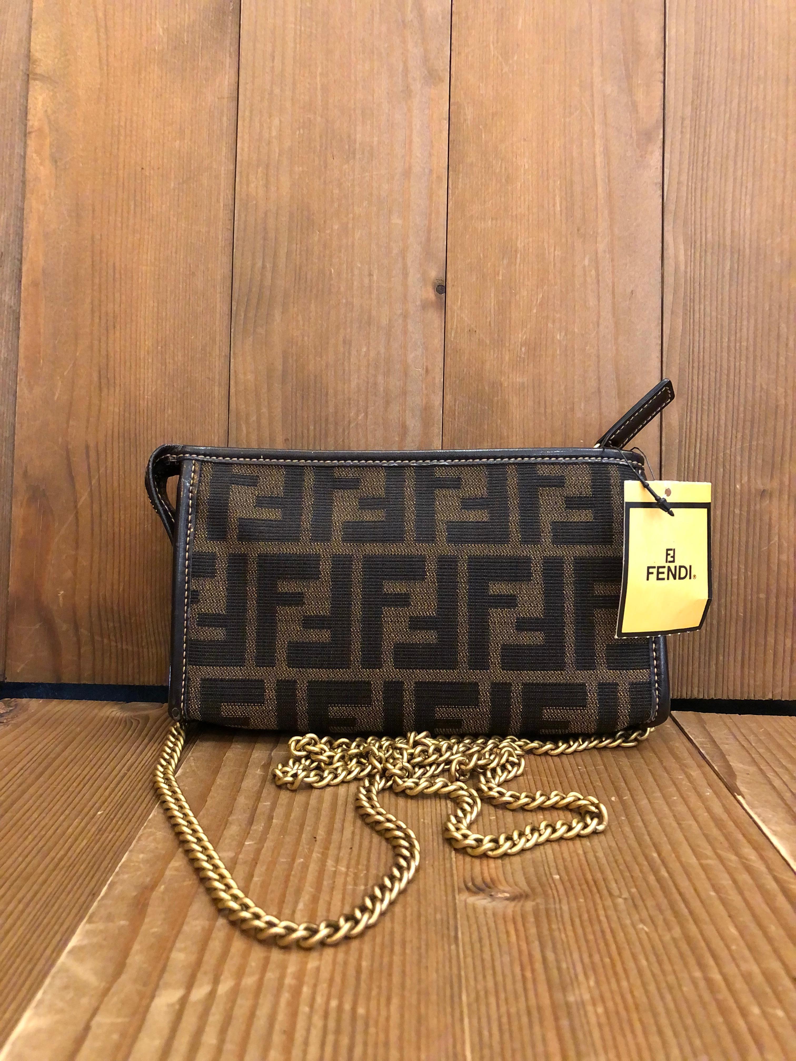 This vintage FENDI pouch is crafted of Fendi's iconic Zucca jacquard in brown trimmed with  leather featuring gold toned hardware. Top zipper closure opens to a beige colored interior. Non-Fendi hardware is added to secure a chain to carry the pouch