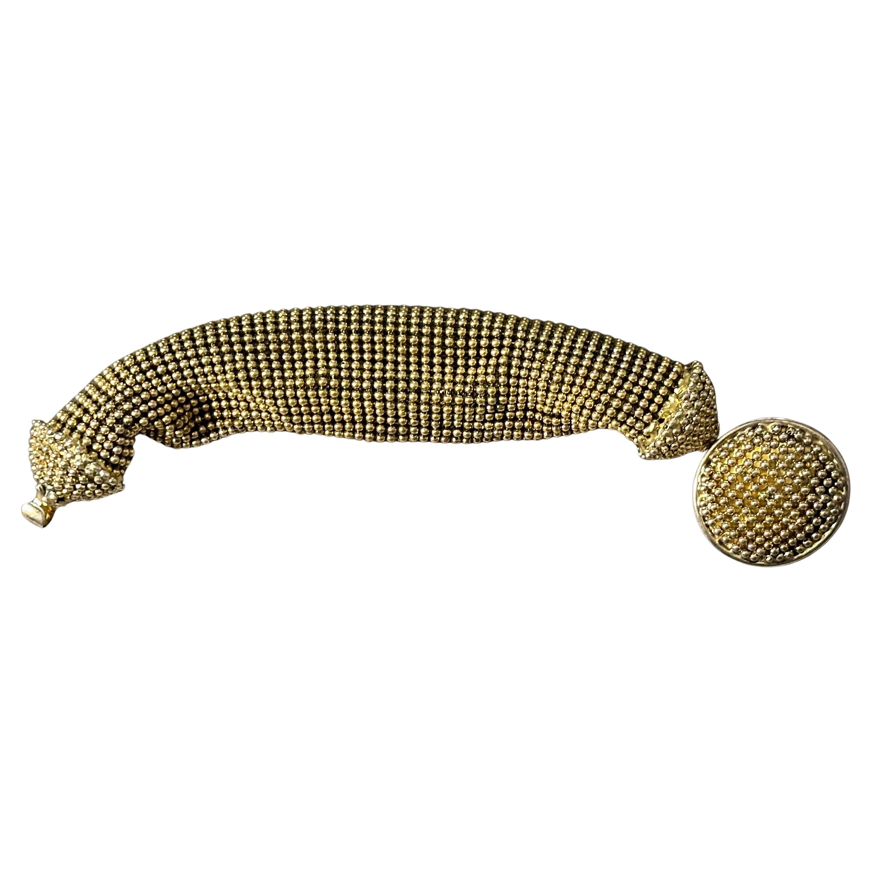 This vintage Giorgio Armani bracelet is a striking and unique piece, showcasing exceptional craftsmanship and timeless style. The bracelet features an intricate design composed of small, gold-tone metal beads woven together in a flexible, mesh-like