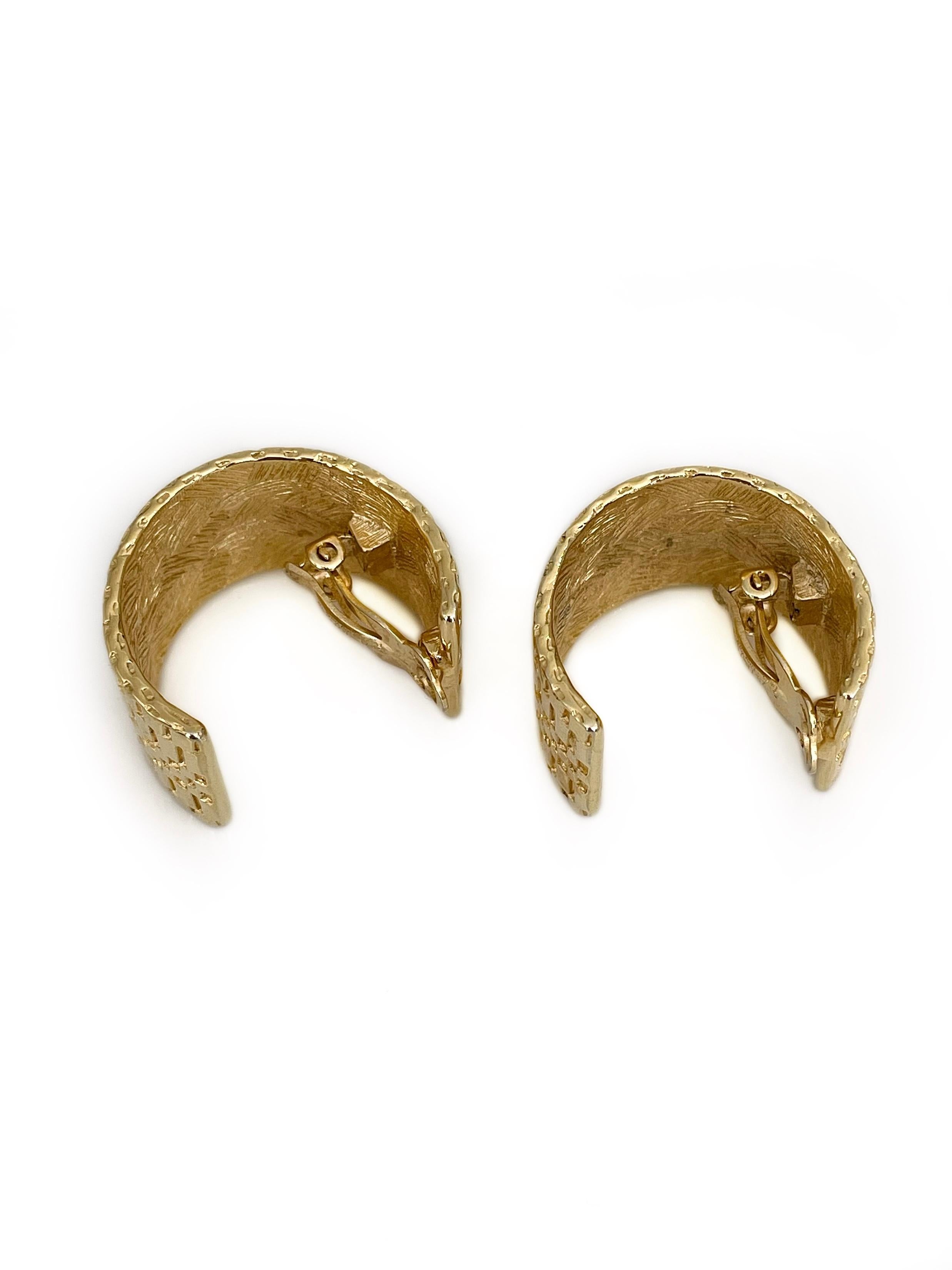 This is a vintage pair of semi hoop clip on earrings designed by Givenchy in 1990’s. This piece is gold plated and subtly textured. 

Signed: 
