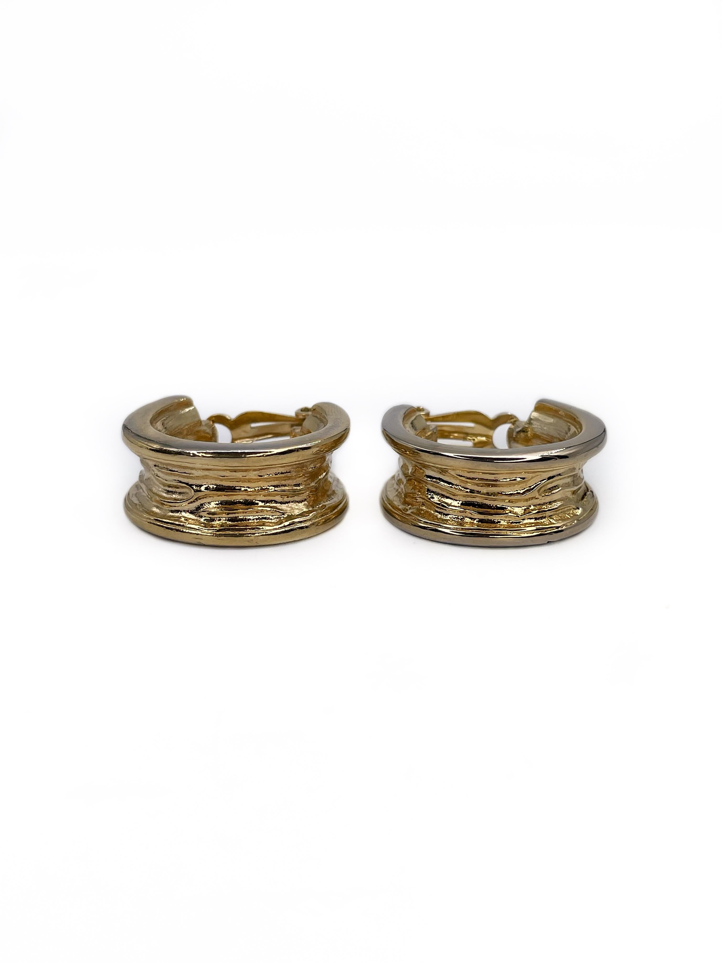 This is a stylish pair of hoop clip on earrings designed by Givenchy in 1990’s. This piece is gold plated and subtly textured. 

There is minor abrasion on the sides. 

Signed: 