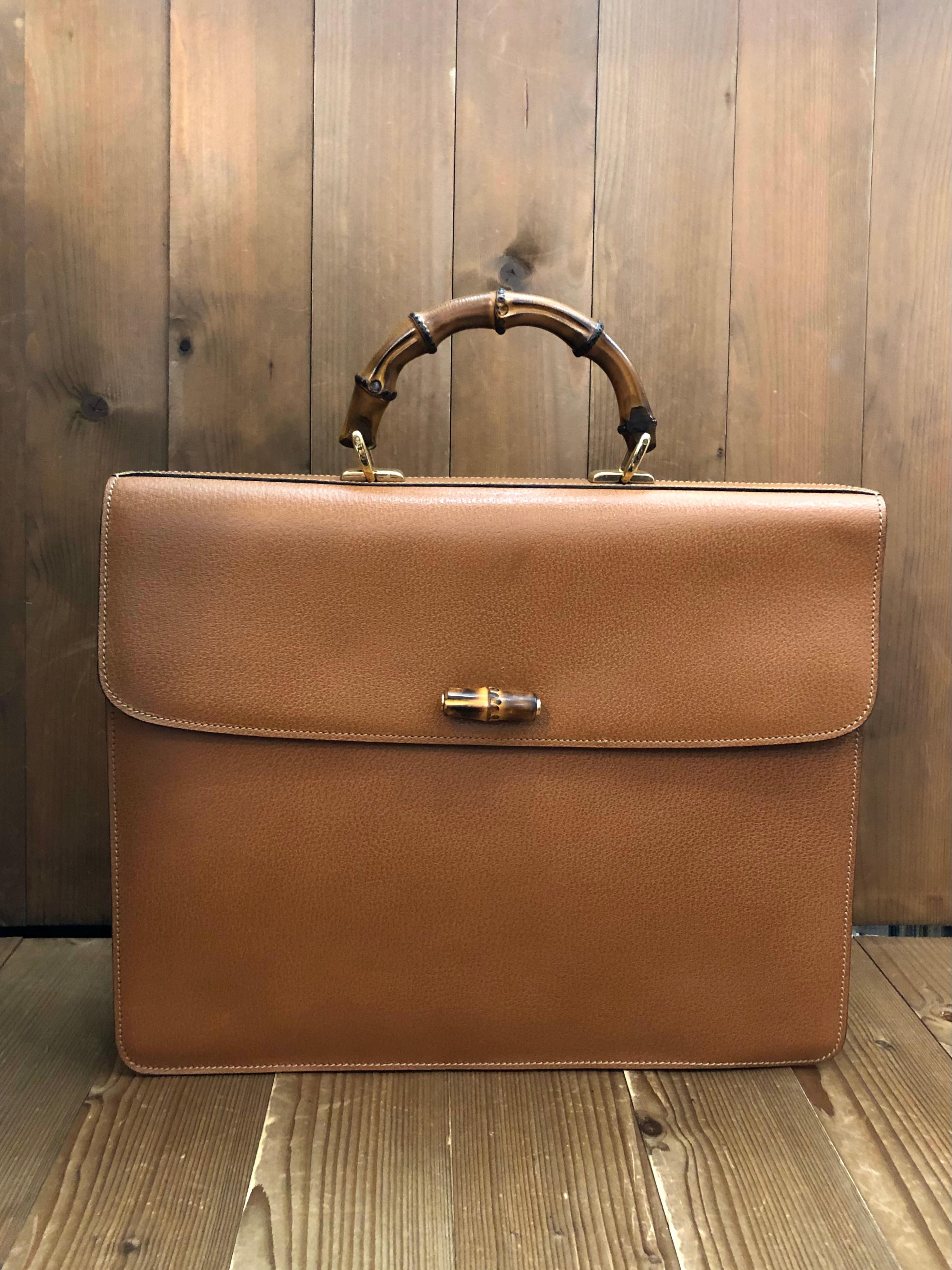 This vintage GUCCI bamboo briefcase/attache is crafted of pigskin leather in caramel brown featuring gold toned hardware and a sturdy bamboo handle. Front pressed-hold bamboo closure opens to a luxurious nubuck interior in neutral color featuring