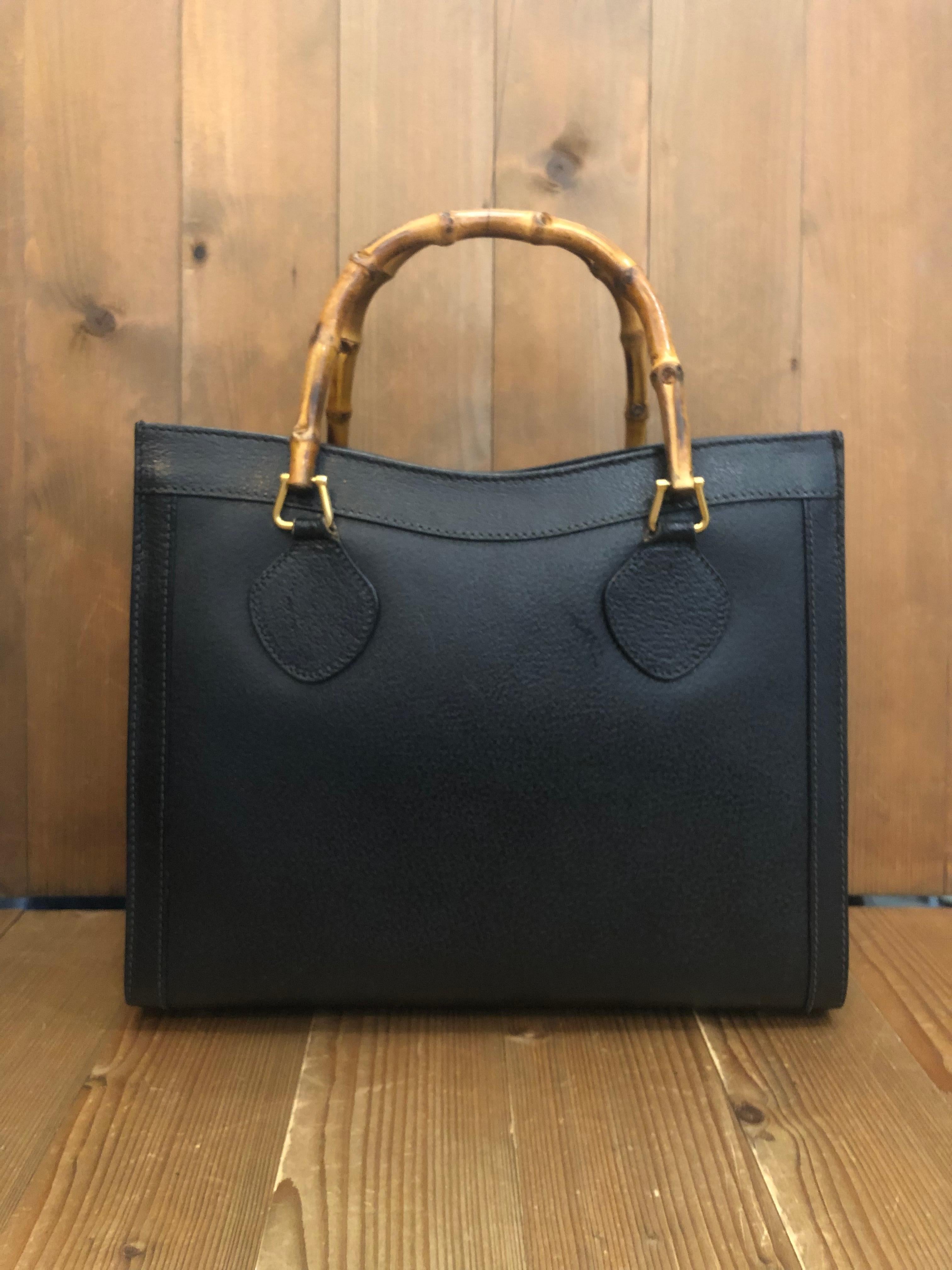 This vintage Gucci bamboo Diana tote is crafted of pigskins leather in black featuring gold toned hardware. Top magnetic snap closure opens to a new interior in black. It features two main compartments/one zippered compartment and one interior zip