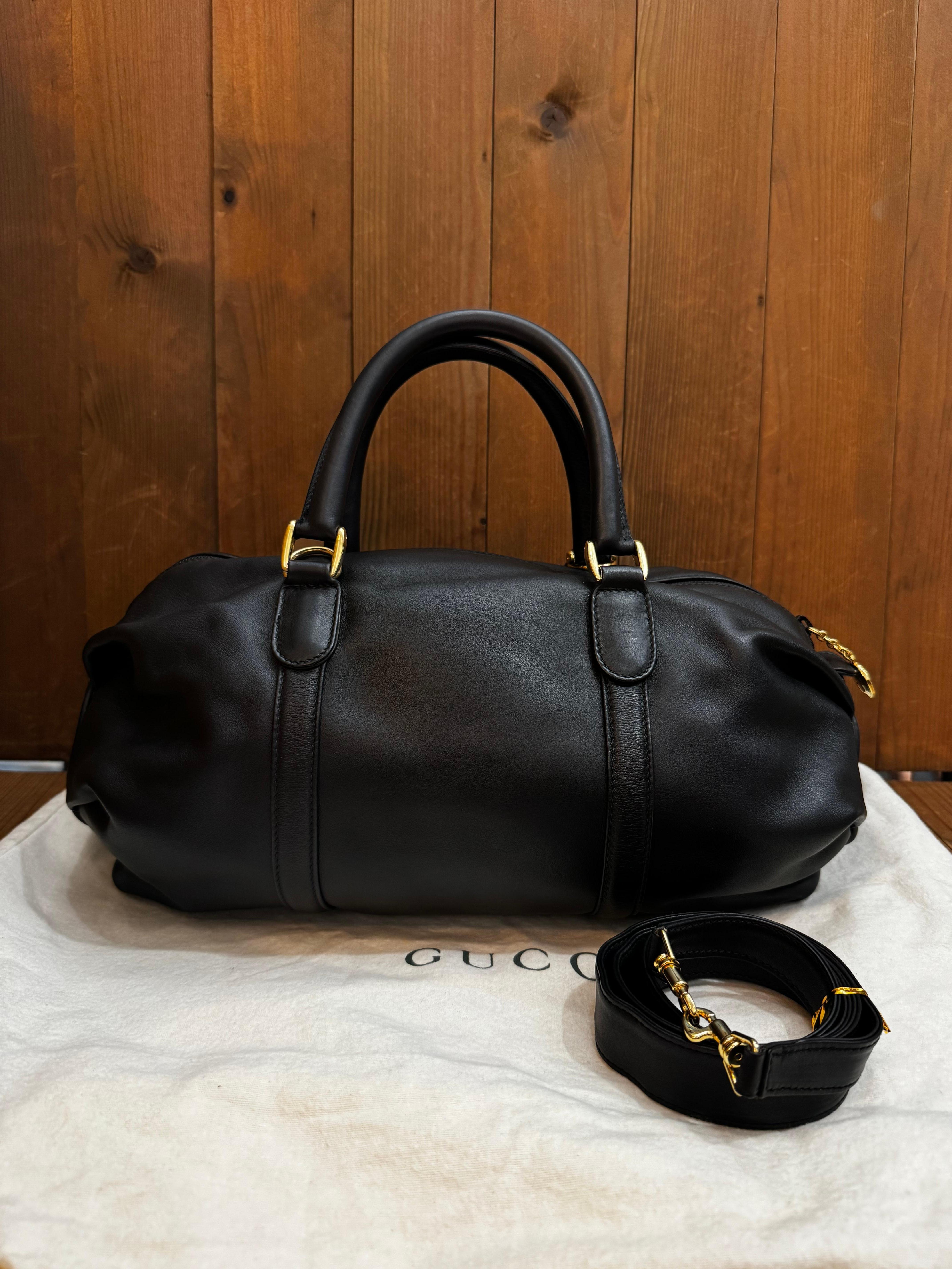 This vintage GUCCI boston bag is crafted of soft smooth calfskin leather in black featuring gold toned hardware and rolled leather handles. Top zipper closure opens to a luxurious nubuck interior in black featuring a zippered pocket. This boston bag